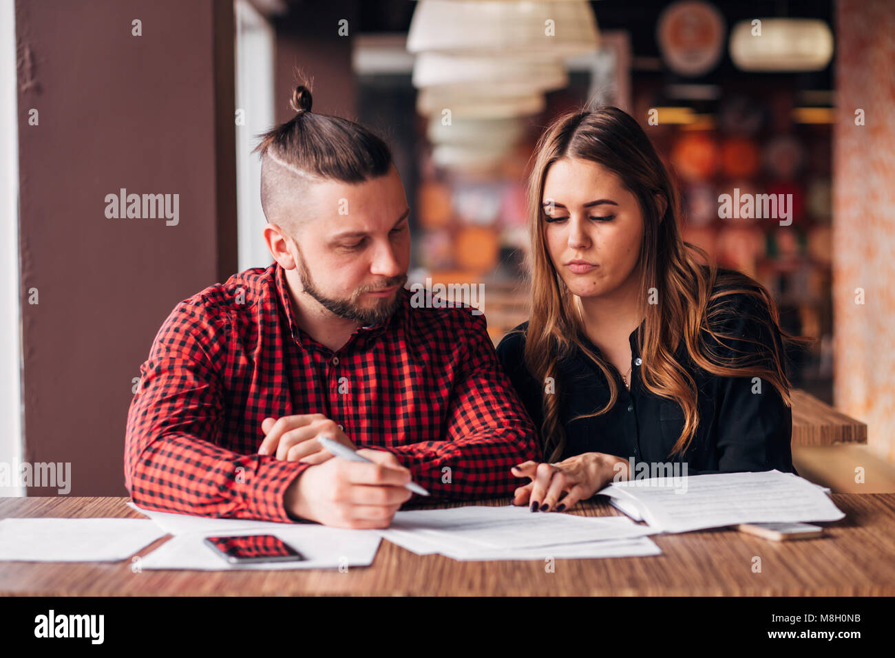 Les jeunes entrepreneurs ont conclu un accord dans un café, la signature de documents Banque D'Images