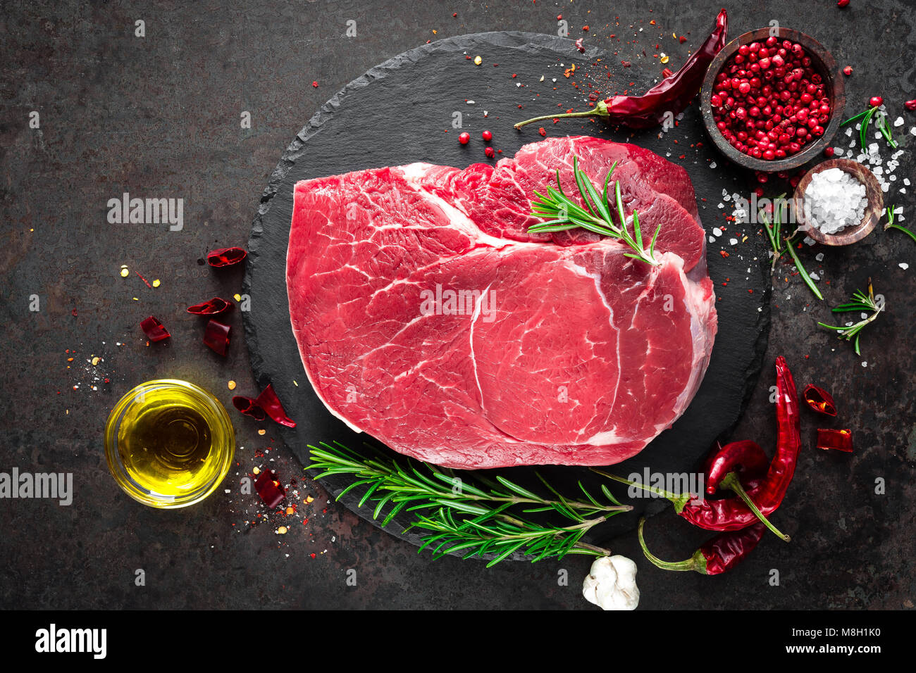 Steak de boeuf cru sur fond noir avec des ingrédients. La viande de boeuf fraîche. Vue d'en haut Banque D'Images