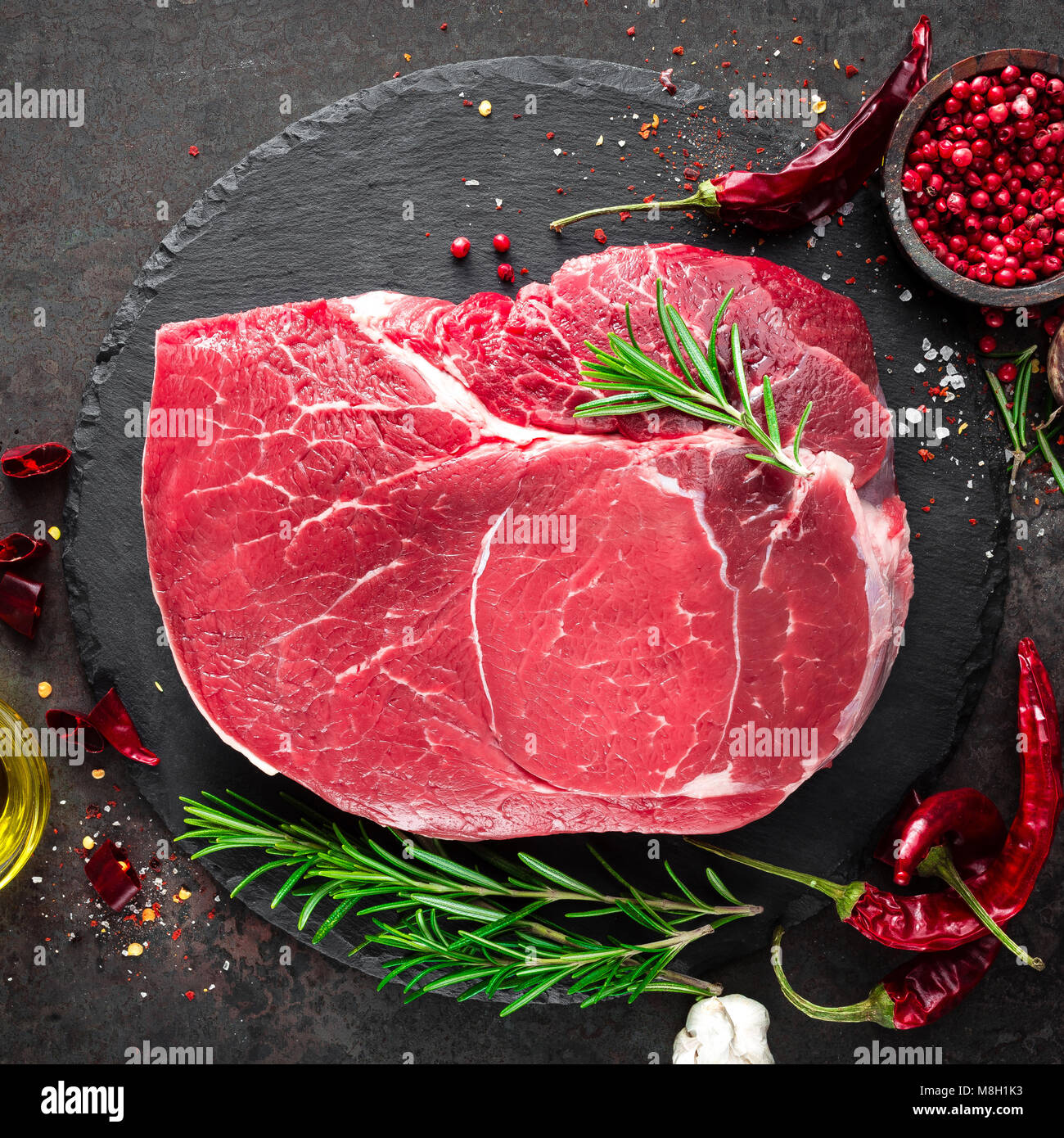 Steak de boeuf cru sur fond noir avec des ingrédients. La viande de boeuf fraîche. Vue d'en haut Banque D'Images