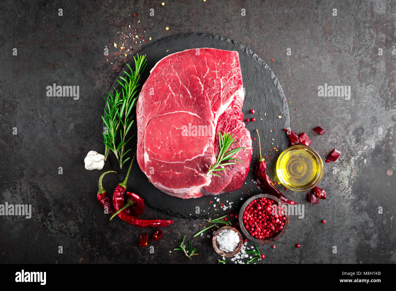 Steak de boeuf cru sur fond noir avec des ingrédients. La viande de boeuf fraîche. Vue d'en haut Banque D'Images