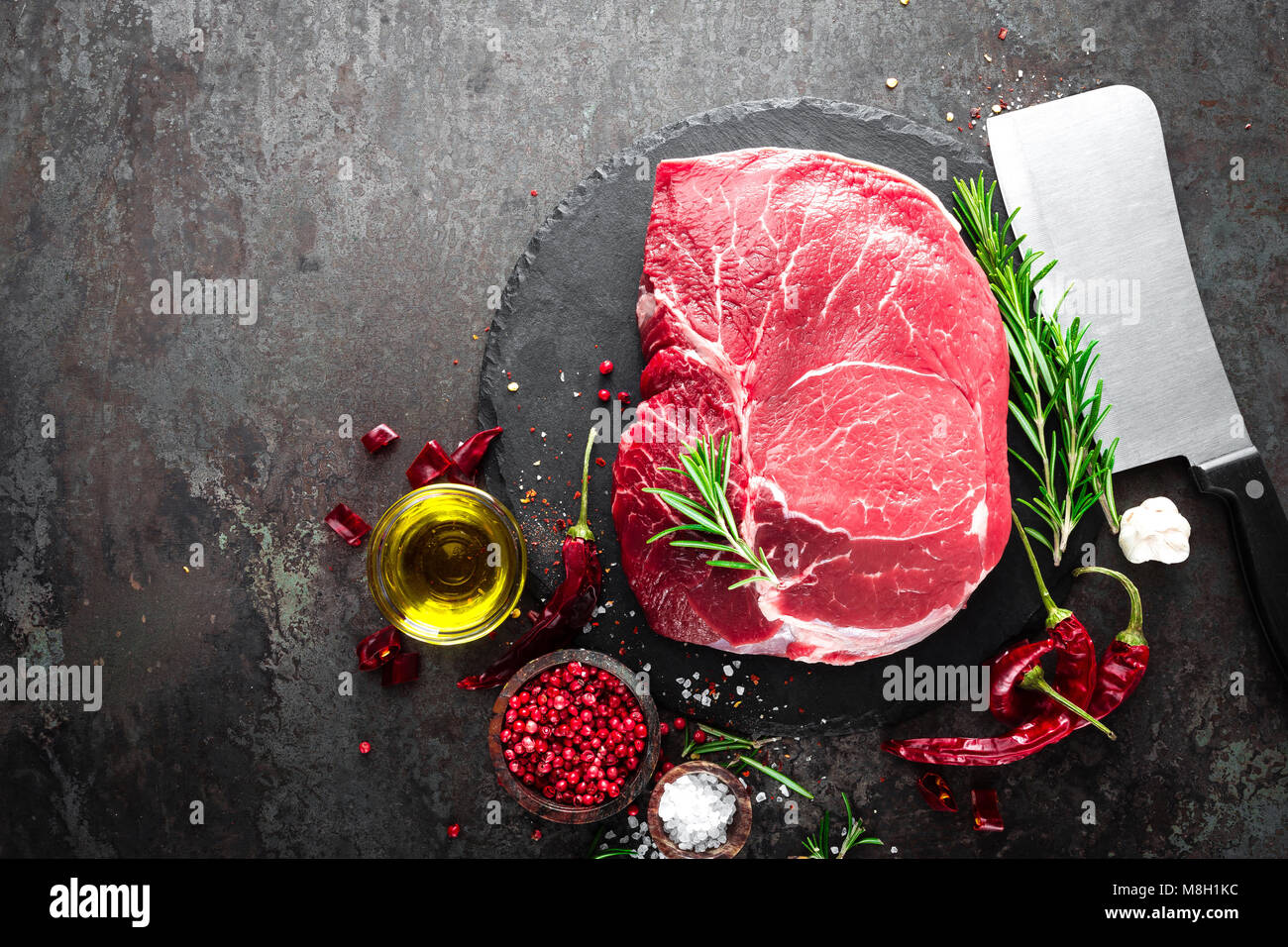 Steak de boeuf cru sur fond noir avec des ingrédients. La viande de boeuf fraîche. Vue d'en haut Banque D'Images