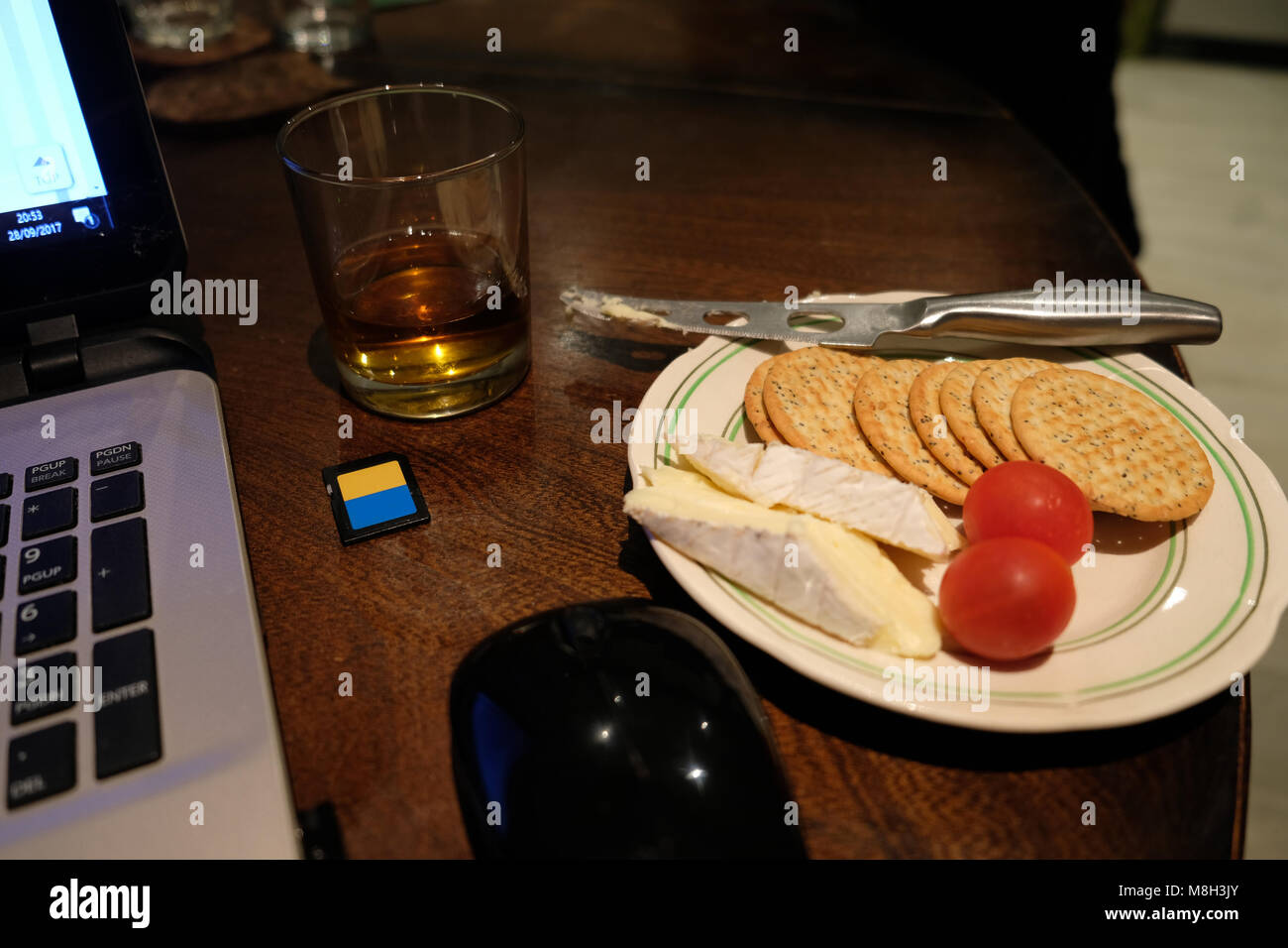 Snack de fin de soirée, les craquelins, brie, tomates cerises et un verre de whisky écossais Banque D'Images