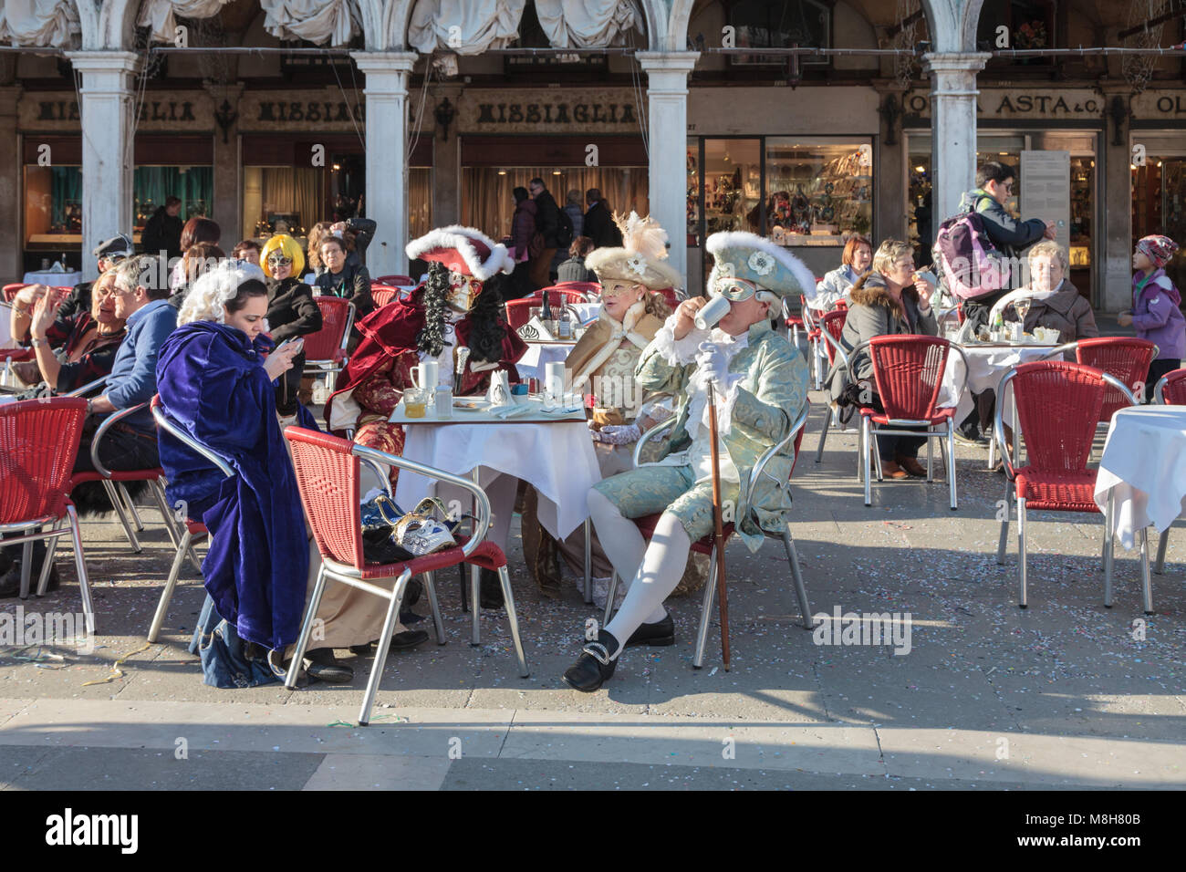 Les gens en déguisements et masque déguisés assis dans un café à la place Saint-Marc, au Carnaval de Venise, à Carnevale di Venezia, en Vénétie, en Italie Banque D'Images