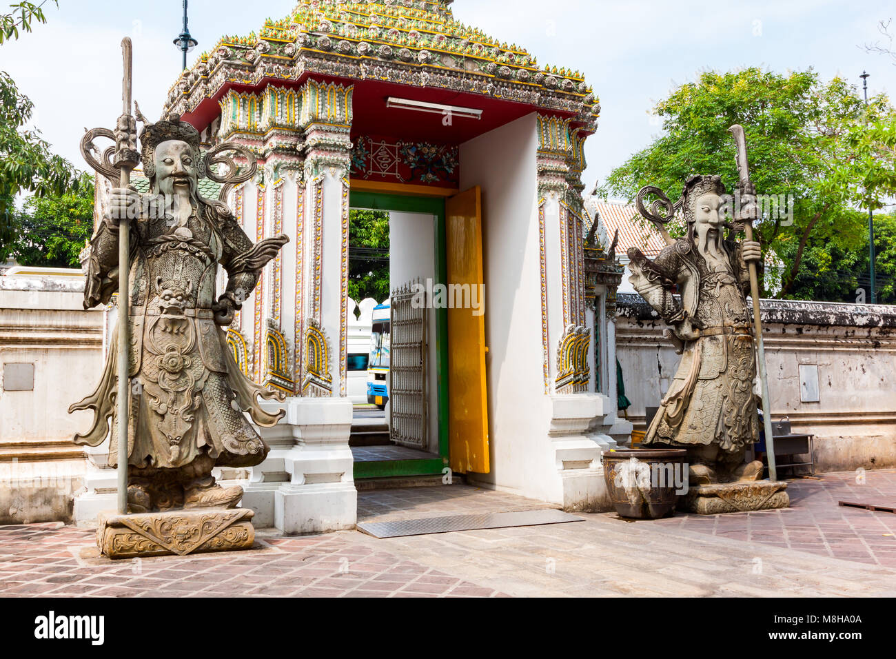 Des géants de la sculpture sur pierre en face de la porte de Wat Pho à Bangkok en Thaïlande Banque D'Images