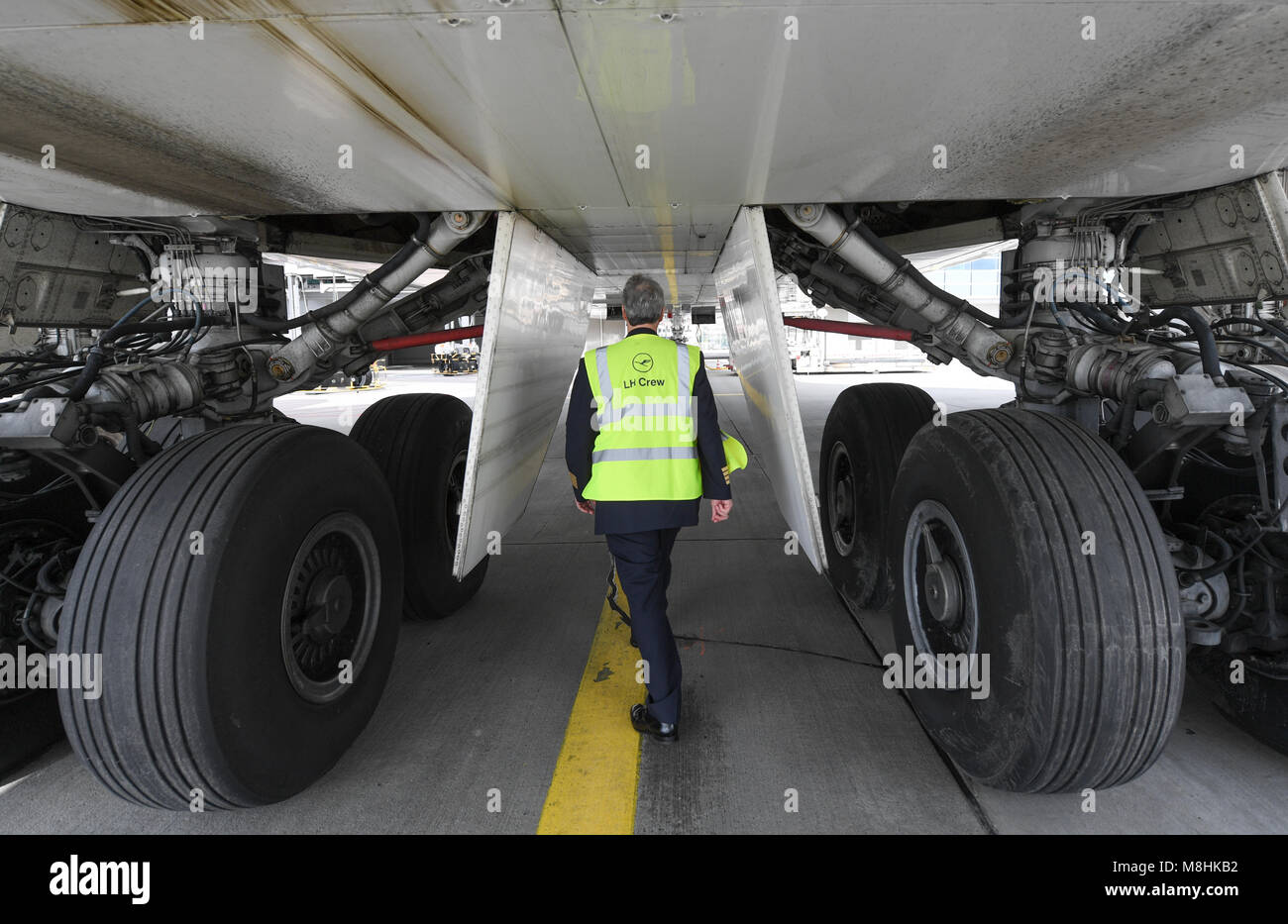 14 mars 2018, l'Allemagne, Francfort : Lufthansa le capitaine Michael Sauer examine l'extérieur d'un Boeing 747-800 de transporteur allemand Lufthansa à l'aéroport de Francfort. Photo : Arne Dedert/dpa Banque D'Images