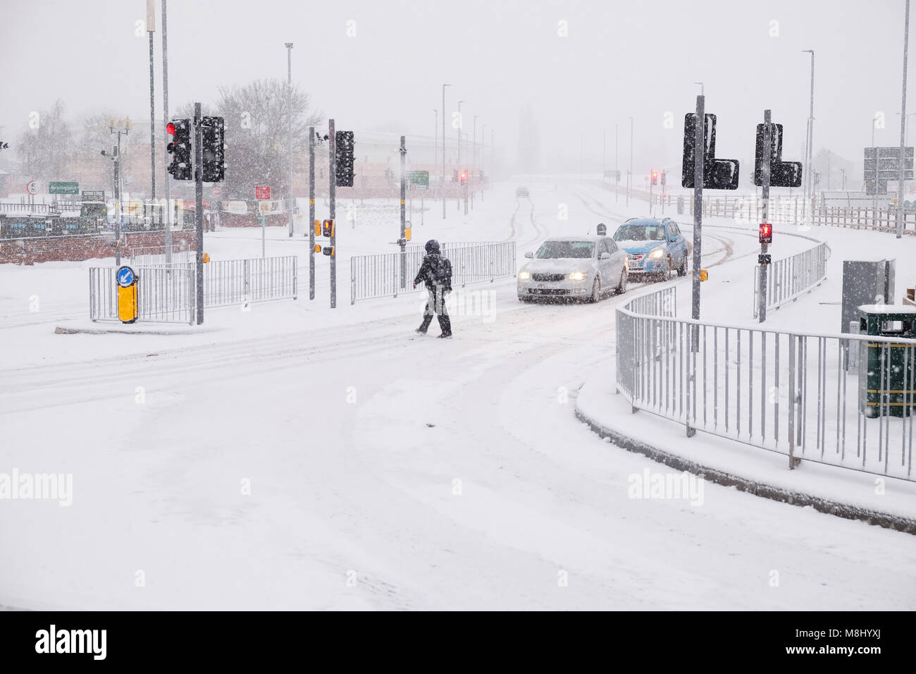 Hereford, Herefordshire, UK - Dimanche 18 Mars 2018 - de fortes chutes de neige de la ville d''Hereford continue pendant la nuit dimanche matin dans la ville de Hereford - un piéton traverse sur les routes couvertes de neige. Steven Mai /Alamy Live News Banque D'Images