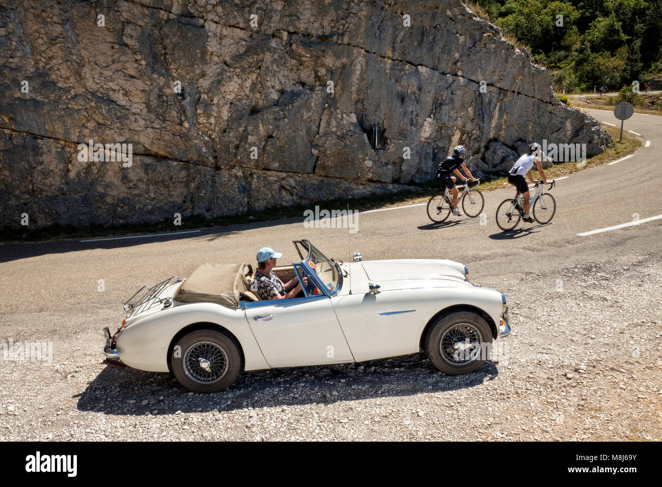 1965 Austin Healey 3000 MKIII sur un col en France avec les cyclistes. Banque D'Images