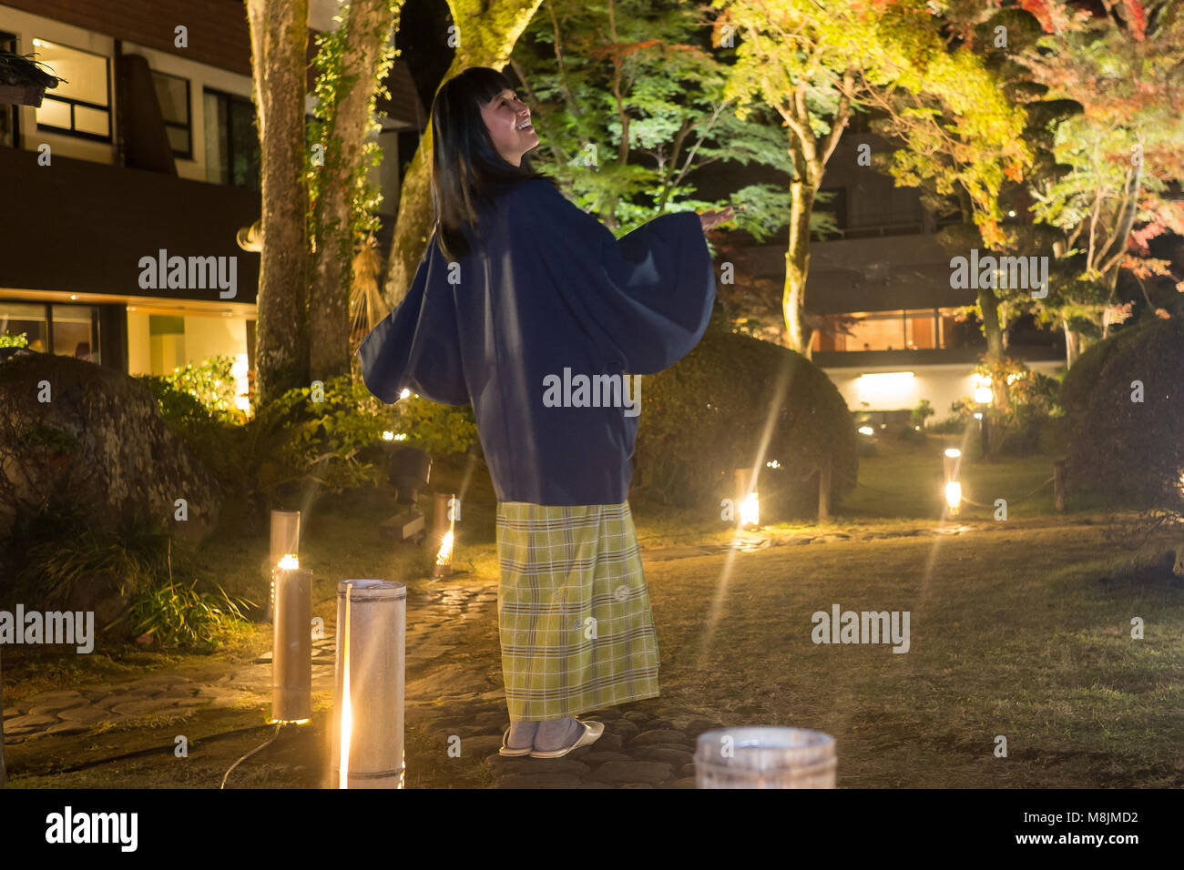Belle jeune femme dans un yukata se promenant dans un jardin japonais Banque D'Images