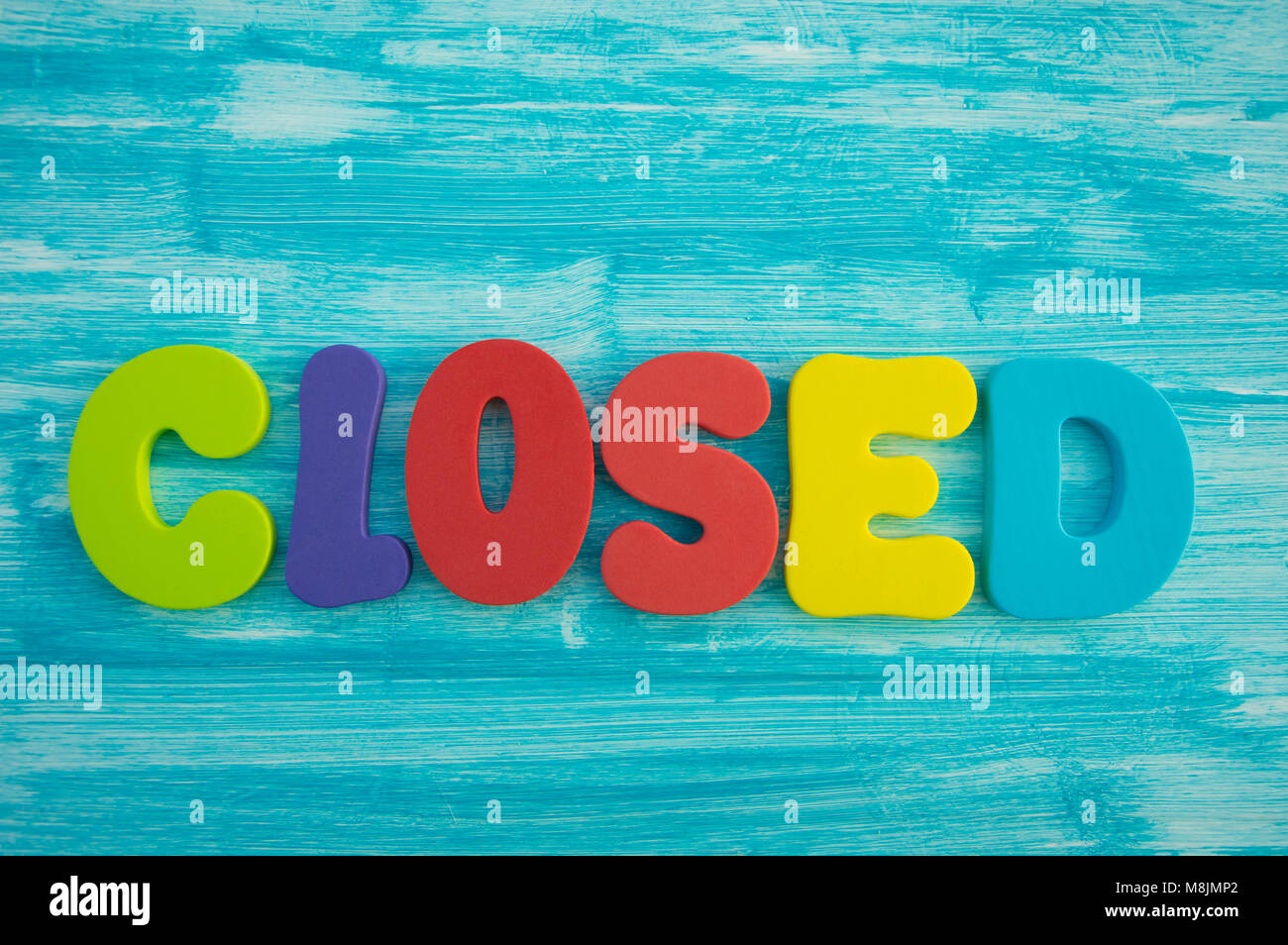 Fermé en lettres capitales sur fond de bois de couleur bleu Banque D'Images