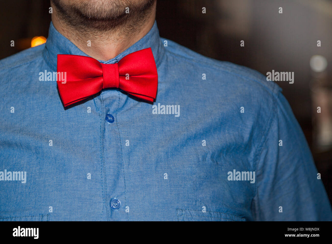 Jeune et beau hipster homme en jean bleu chemise et nœud Papillon rouge sur  fond vintage Photo Stock - Alamy