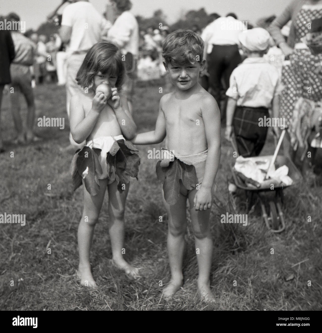 Années 1950, historiques, deux enfants participant à une robe de  compétition lors d'une fête en plein air dans un champ portant leurs tenues  d'Adam et Eve à court ou costumes. La jeune