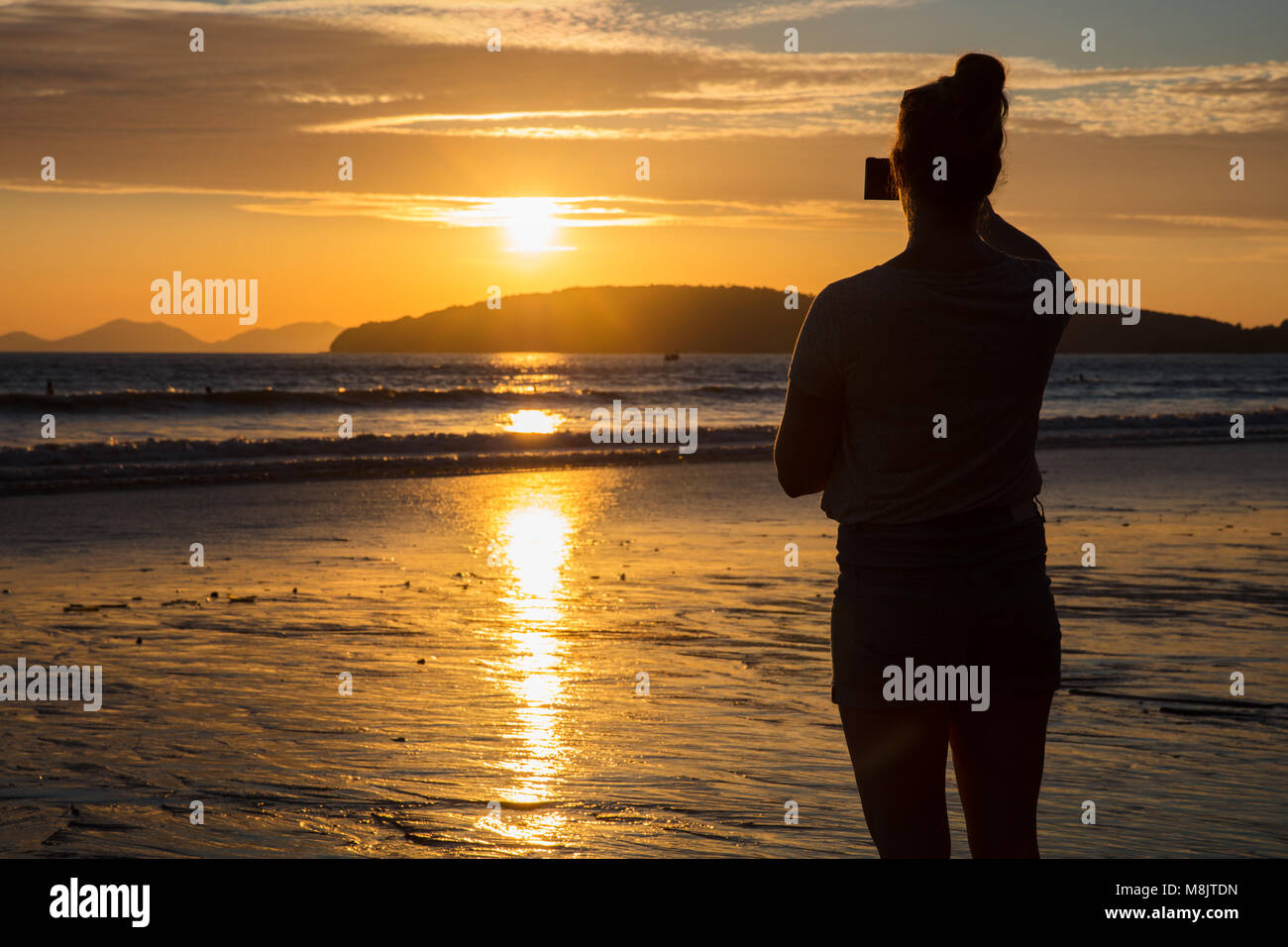 Silhouette Femme photographier le coucher du soleil à Beach Banque D'Images
