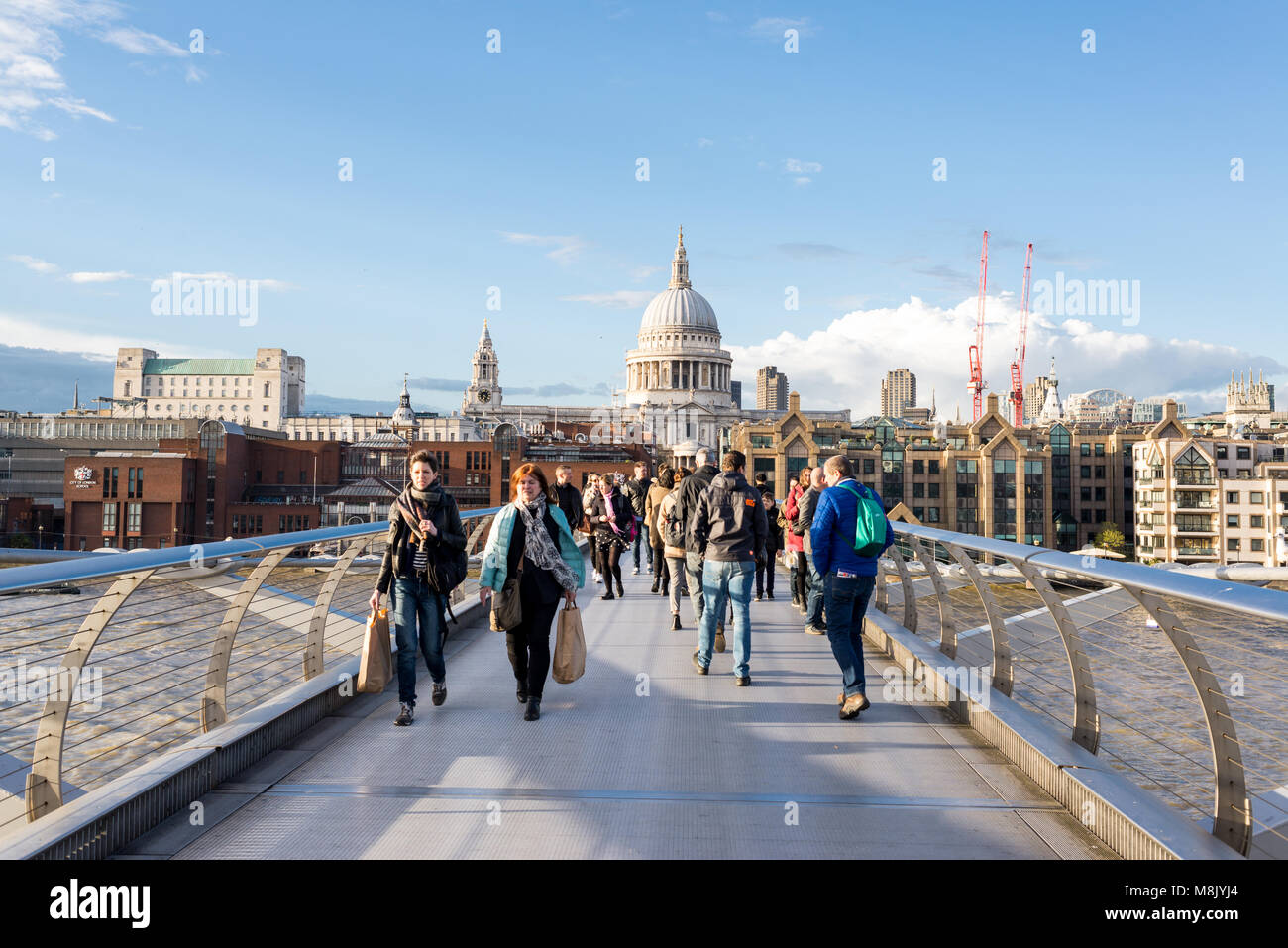 Londres, UK - Avril 2017 : les gens marcher sur le Millenium bridge traversant la Tamise avec une vue sur la Cathédrale St Paul, un jour ensoleillé Banque D'Images