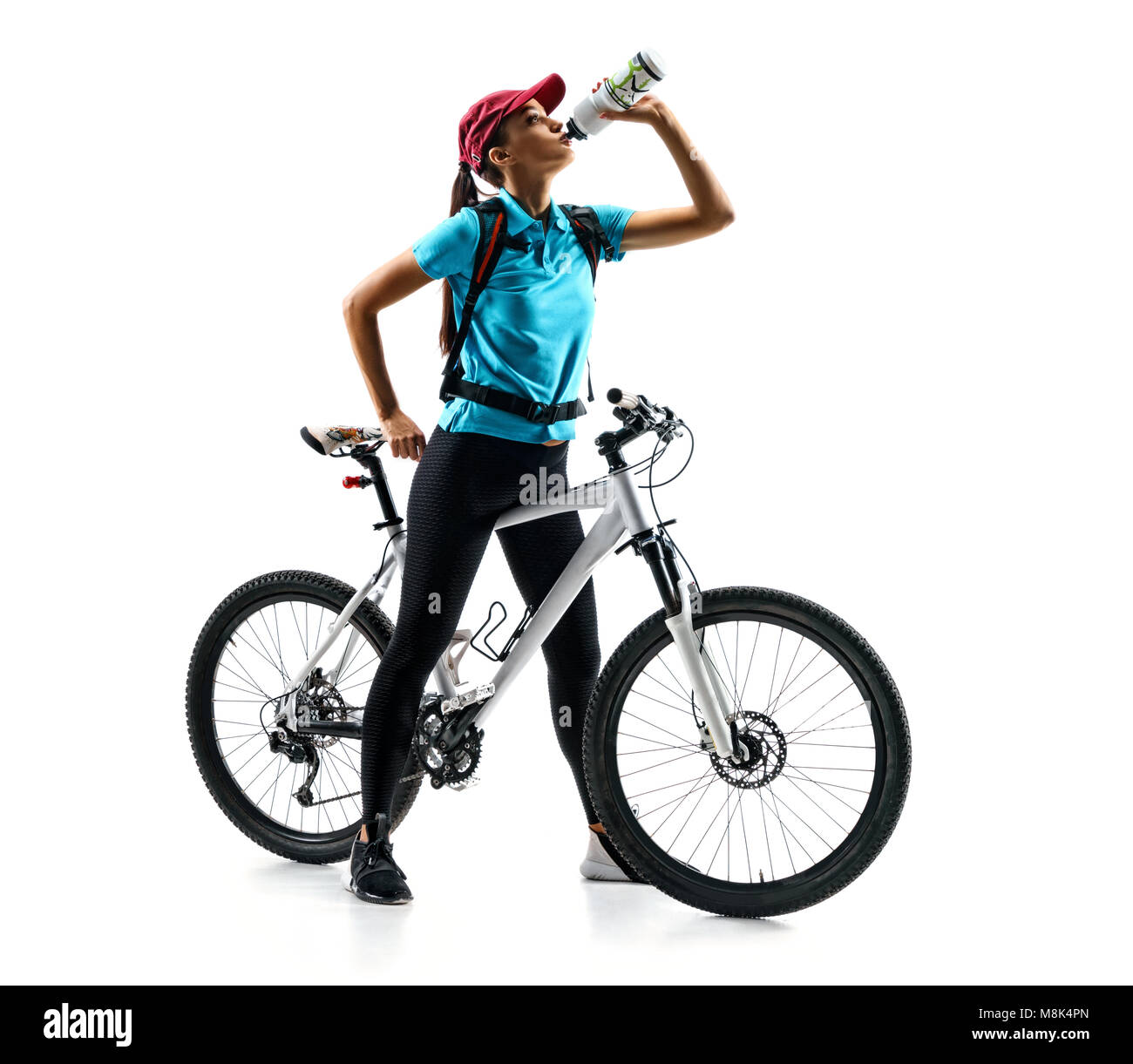 Cycliste de tee-shirt bleu avec de l'eau potable un vélo en silhouette sur fond blanc. Sport et mode de vie sain Banque D'Images