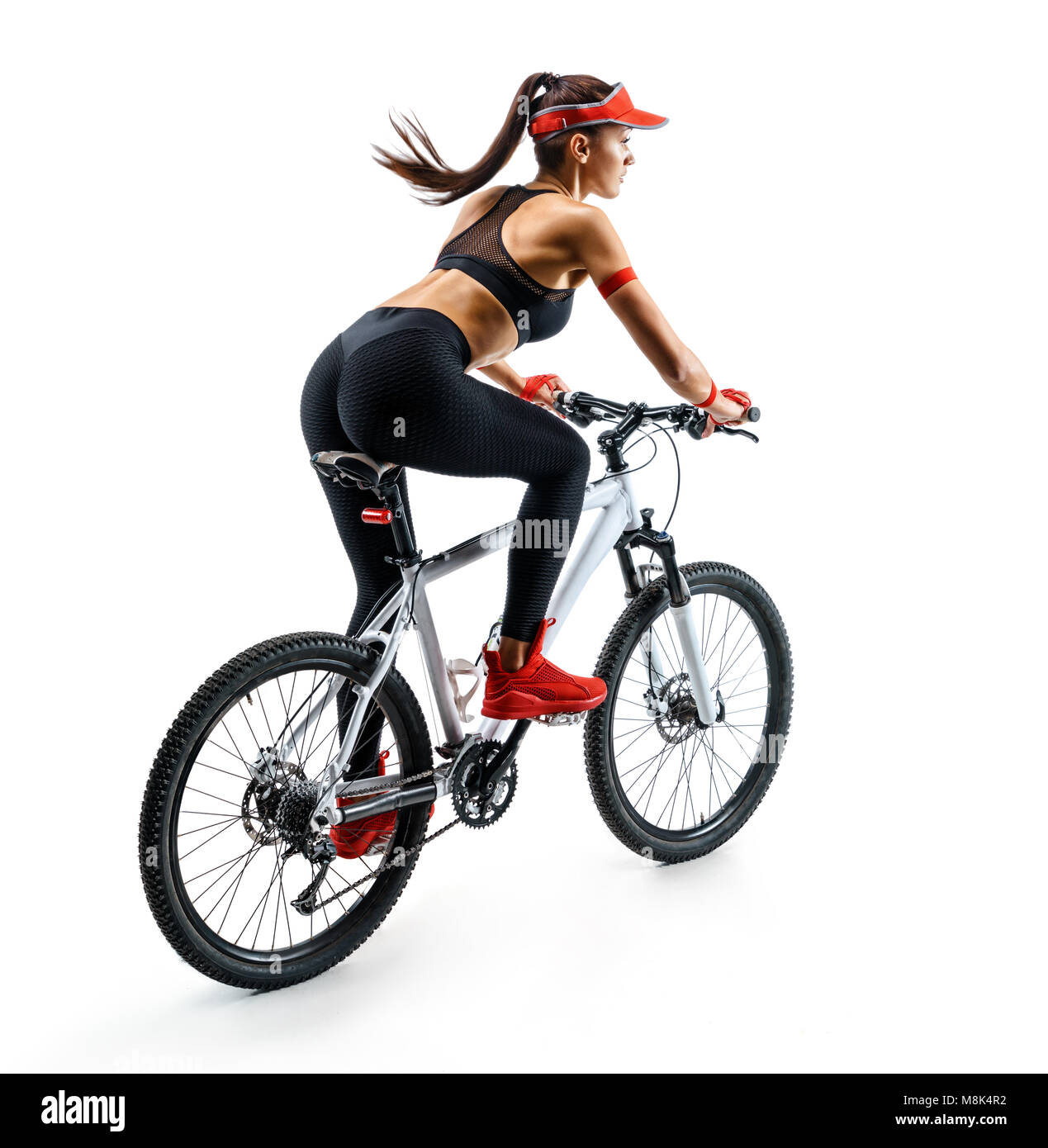 La vie active. Femme sportive pratiquer sur la bicyclette en silhouette sur fond blanc. Vue arrière. Sport et mode de vie sain Banque D'Images