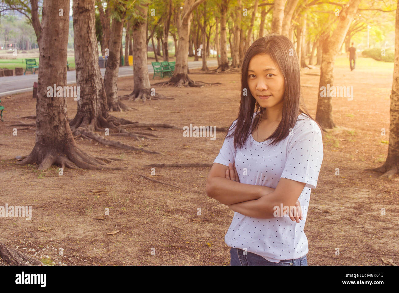 Maison de vacances et de Concept : Woman wearing white t-shirt. Elle debout sur l'herbe verte et le sentiment de bonheur et vous détendre dans le parc. Banque D'Images
