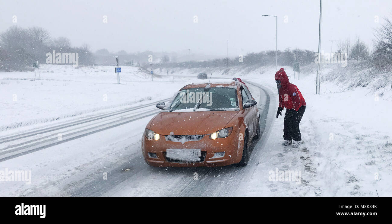 Membre de l'équipe de recherche et de sauvetage Dartmoor aide un automobiliste sur une route de l'A30 près de Okehampton Devon comme beaucoup de neige a apporté le chaos de la circulation à certaines parties du sud-ouest. Banque D'Images