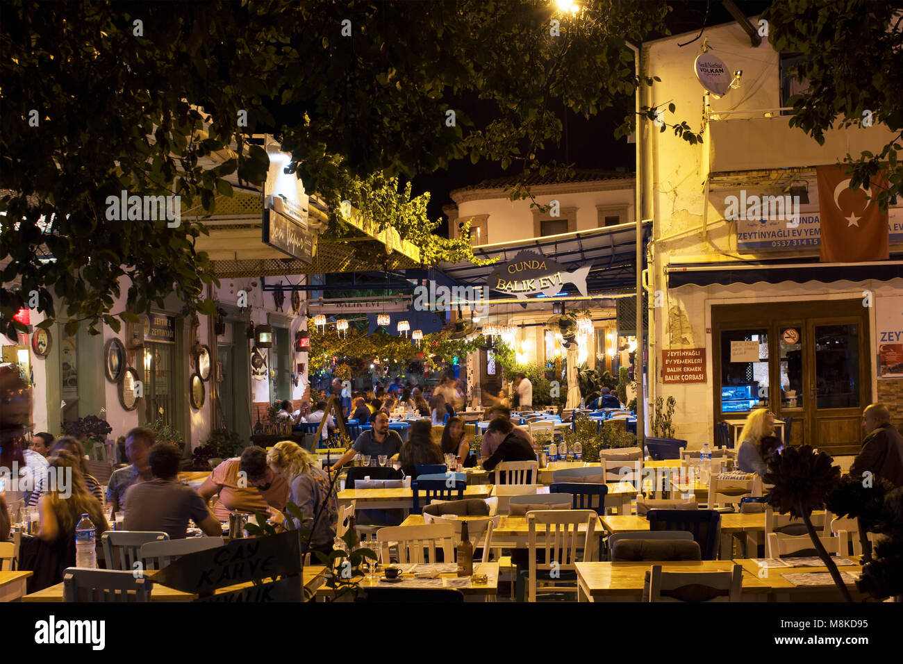 Longtemps exposée (flou de mouvement) image des personnes en train de dîner à l'extérieur de la vieille ville de l'île de Cunda Alibey (). Image montre le mode de vie et la culture de la région. Banque D'Images