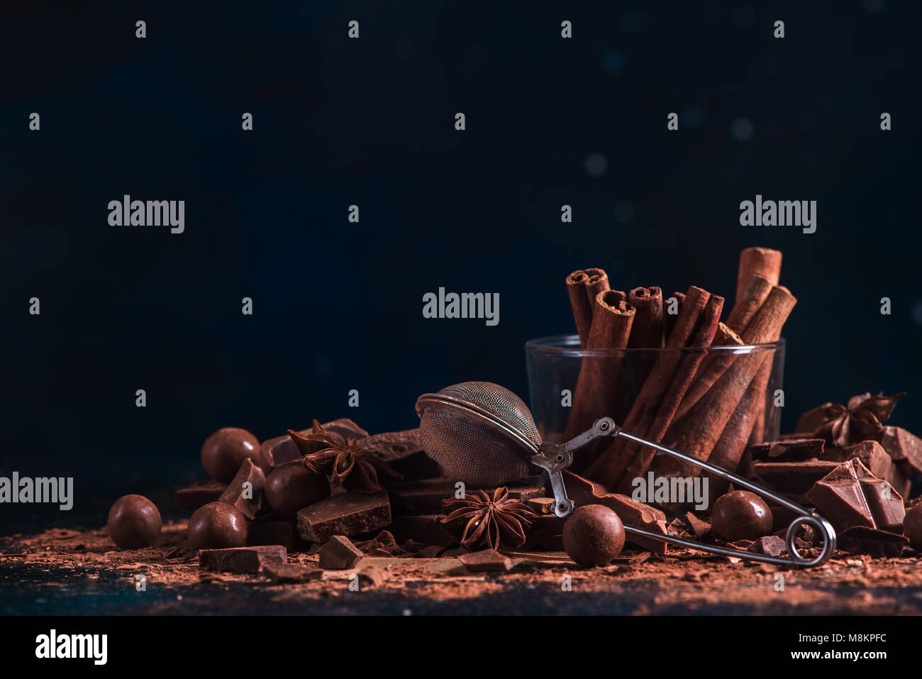La cannelle dans du verre brisé la guerre avec morceaux de chocolat, poudre de cacao et à l'anis étoile. Concept de cuisine dessert avec copie espace. Chocolat maison ingredie Banque D'Images