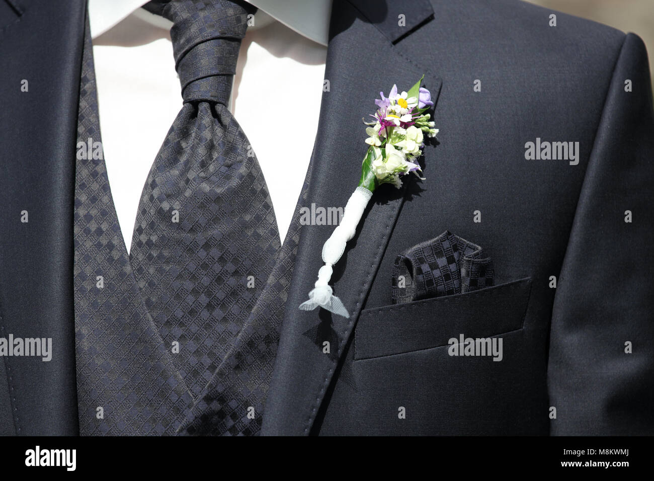 Un homme sur son mariage dans un costume avec bouquet de mariage Banque D'Images