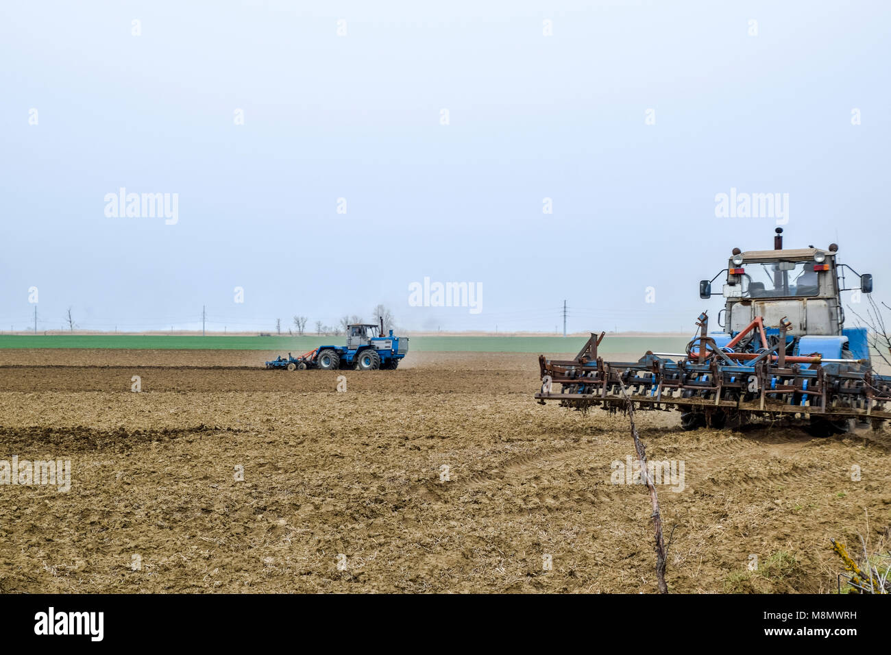 Lush et desserrer le sol sur le terrain avant de semer. Le tracteur laboure un champ avec une charrue Banque D'Images