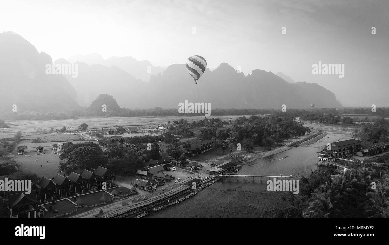 Vue aérienne par Drone : montgolfière sur la rivière Nam Song à Vang Vieng, Laos sur le coucher du soleil. Le noir et blanc Banque D'Images