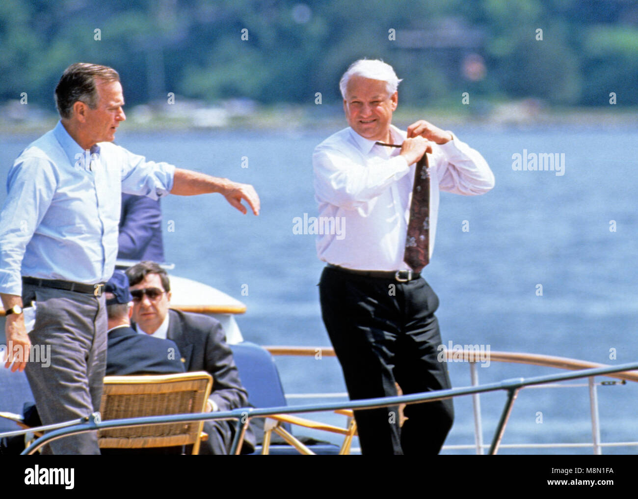 Le président Boris Eltsine, de la Fédération de Russie, la droite, supprime sa cravate alors que lui et le président des États-Unis George H. W. Bush, à gauche, faire une balade en bateau sur la rivière Severn dans le Maryland le 17 juin 1992. Credit : Ron Sachs / CNP /MediaPunch Banque D'Images