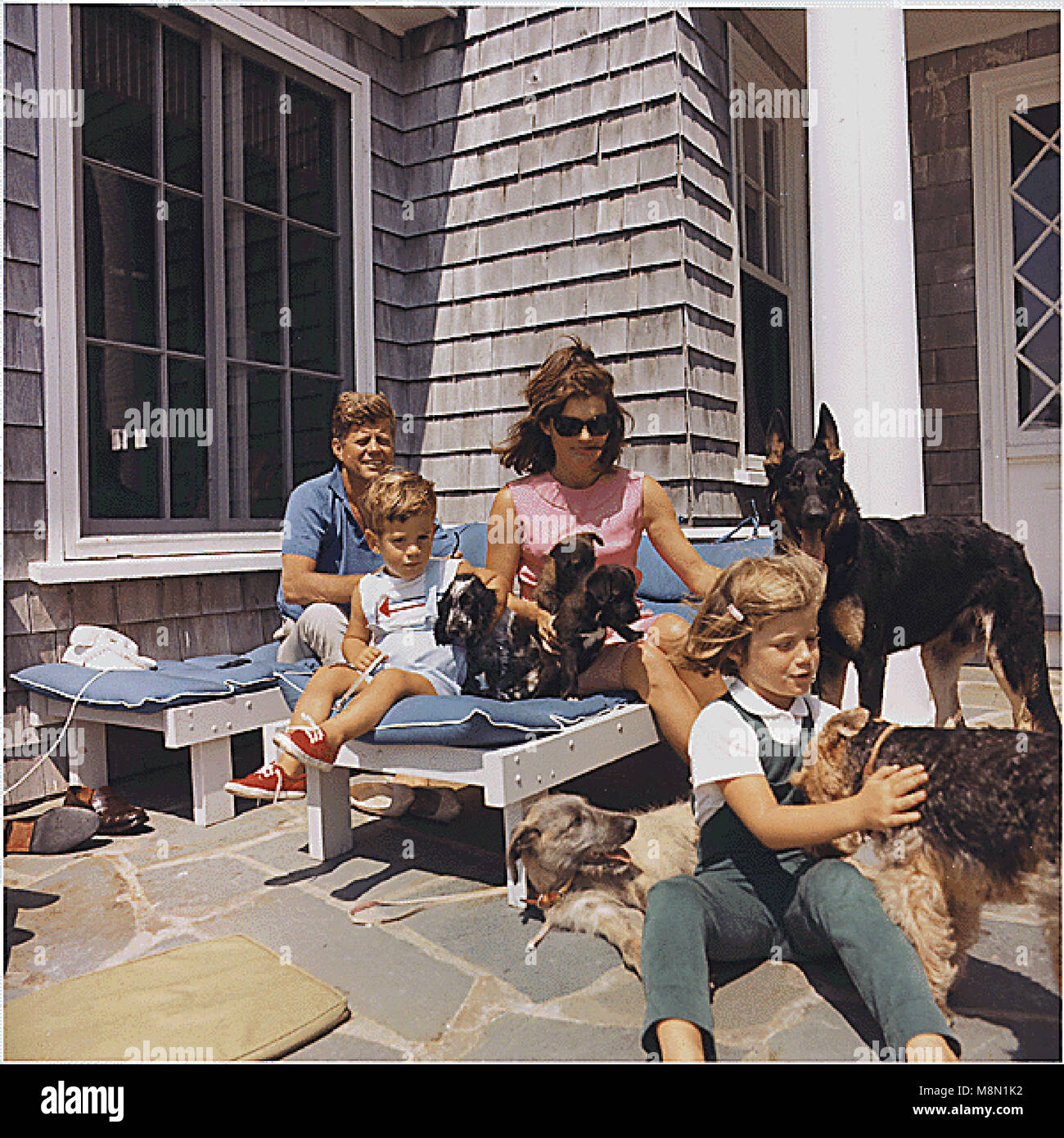 Hyannisport, MA - 14 août 1963 -- Le président des États-Unis John F. Kennedy, John F. Kennedy Jr., Première Dame Jacqueline Kennedy, Caroline Kennedy. Chiens : 37 (debout), Charlie (avec Caroline), Wolf (chaise), Shannon ( avec John Jr. ), deux des chiots de Pushinka (avec Mme Kennedy). Credit : Maison Blanche / CNP /MediaPunch Banque D'Images