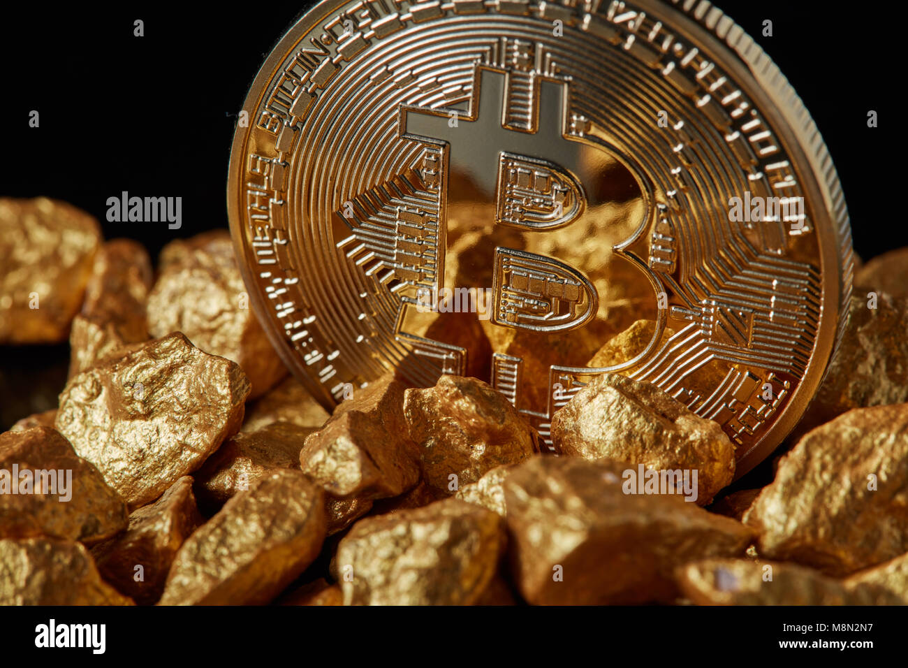 Gros plan du Bitcoin Gold Coin et pépite d'or sur fond noir. Banque D'Images