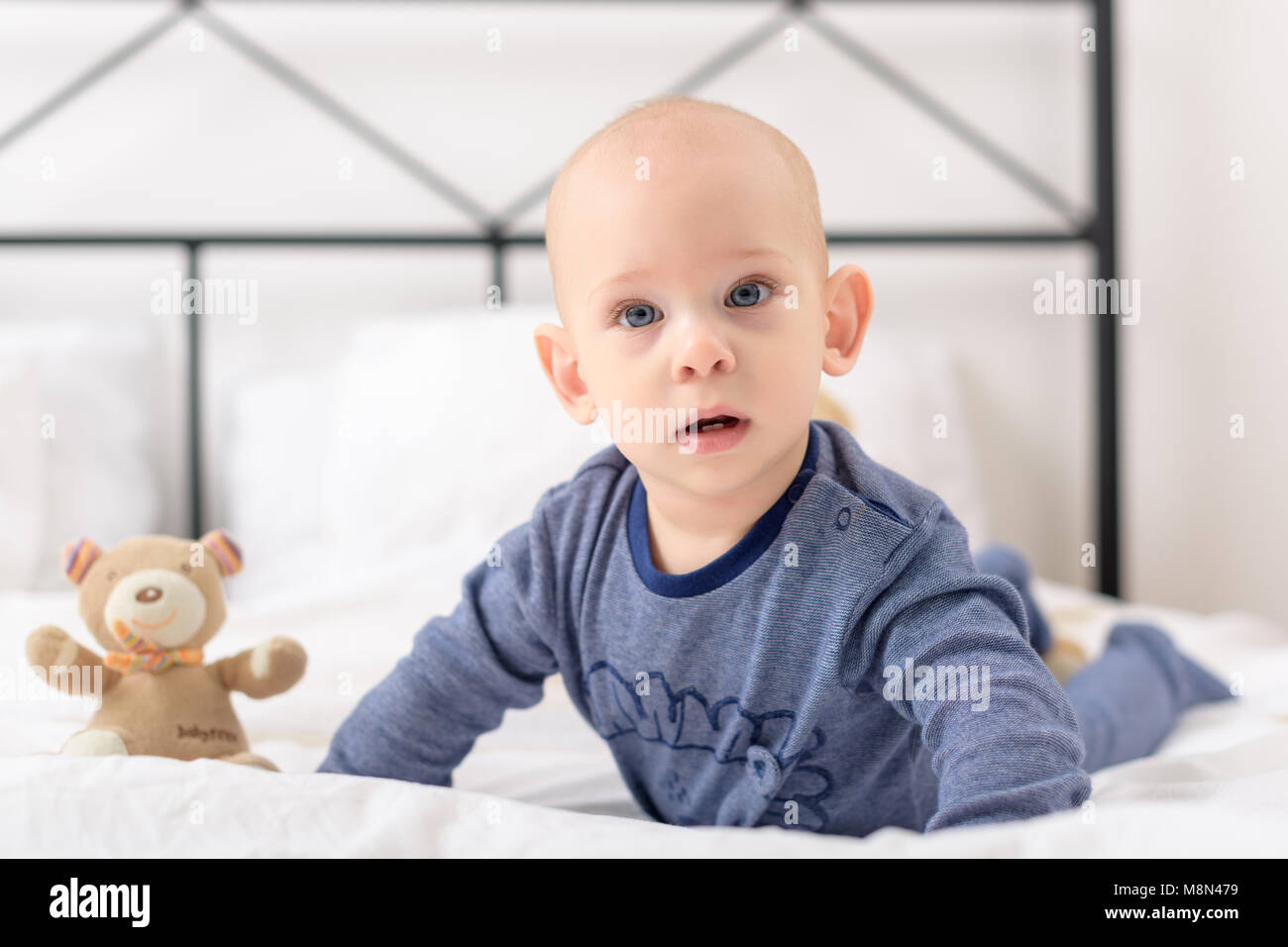 Adorable bébé garçon lplaying avec toy porte sur un lit. Le nouveau-né de se détendre dans le lit. Matin de la famille à la maison. Banque D'Images