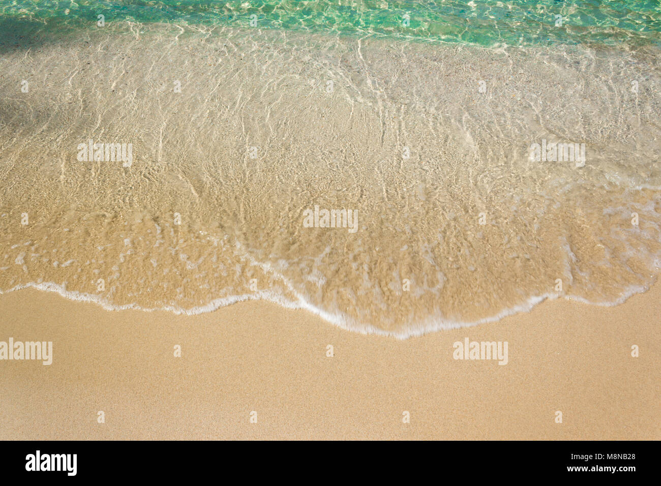 Vagues douces avec mousse de bleu océan sur la plage de sable Banque D'Images