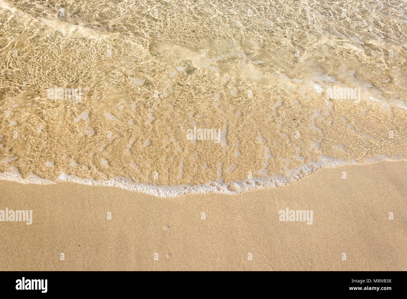 Vagues douces avec de la mousse de l'océan sur la plage de sable contexte Banque D'Images