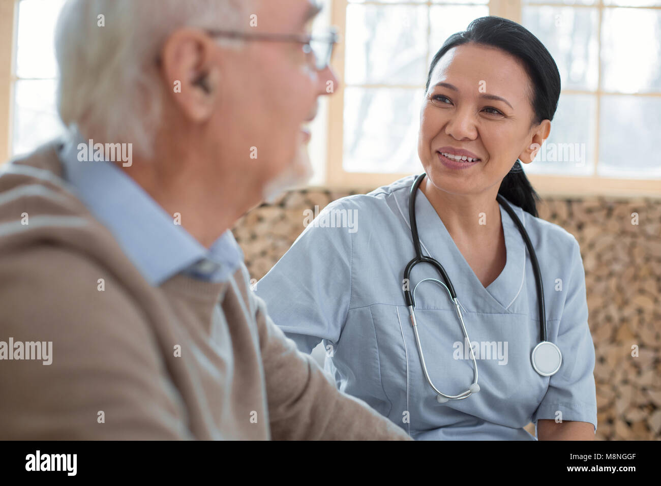 Médecin optimiste en prenant soin de man Banque D'Images