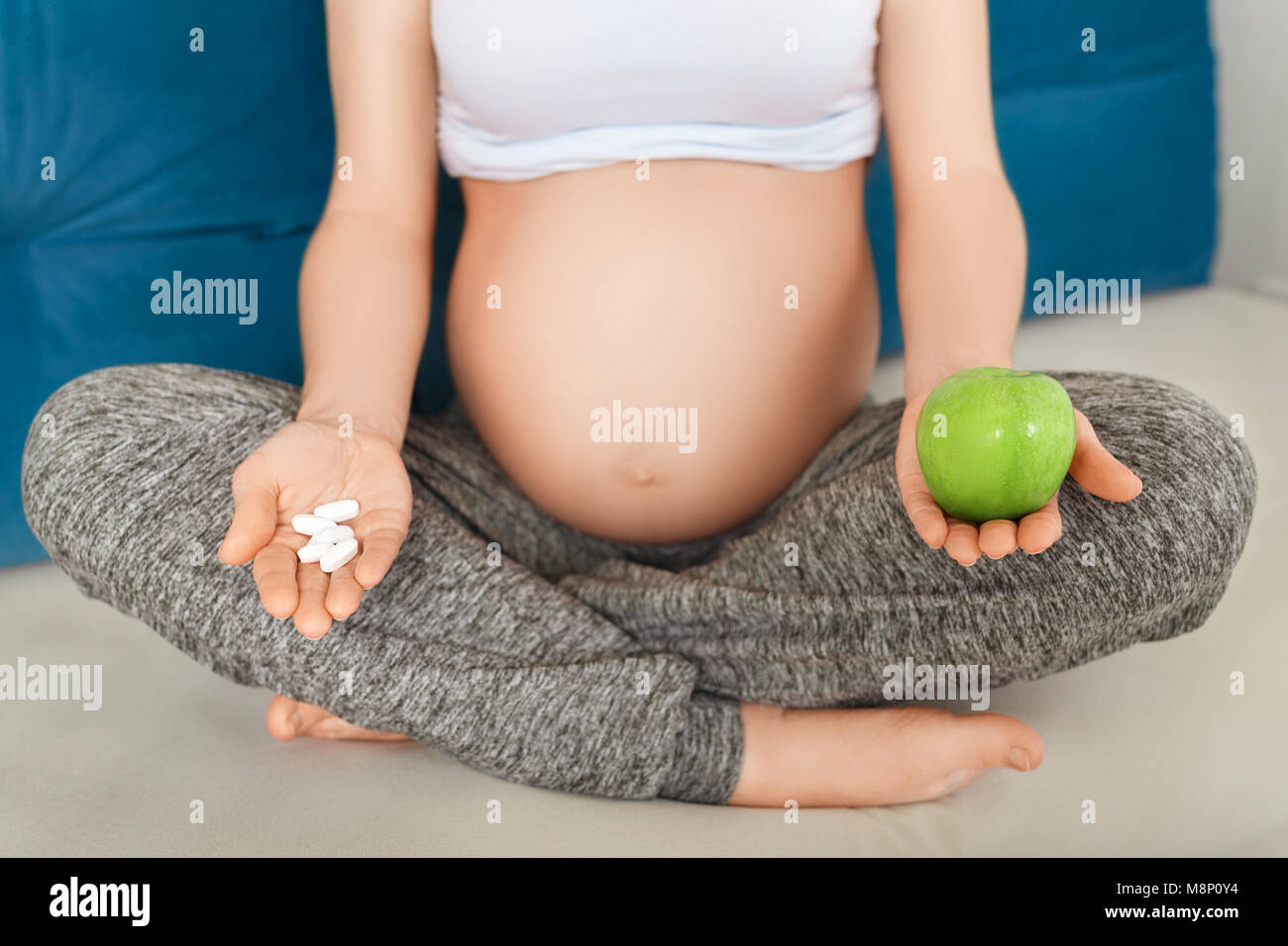 Femme enceinte choix comprimés ou de fruits Banque D'Images