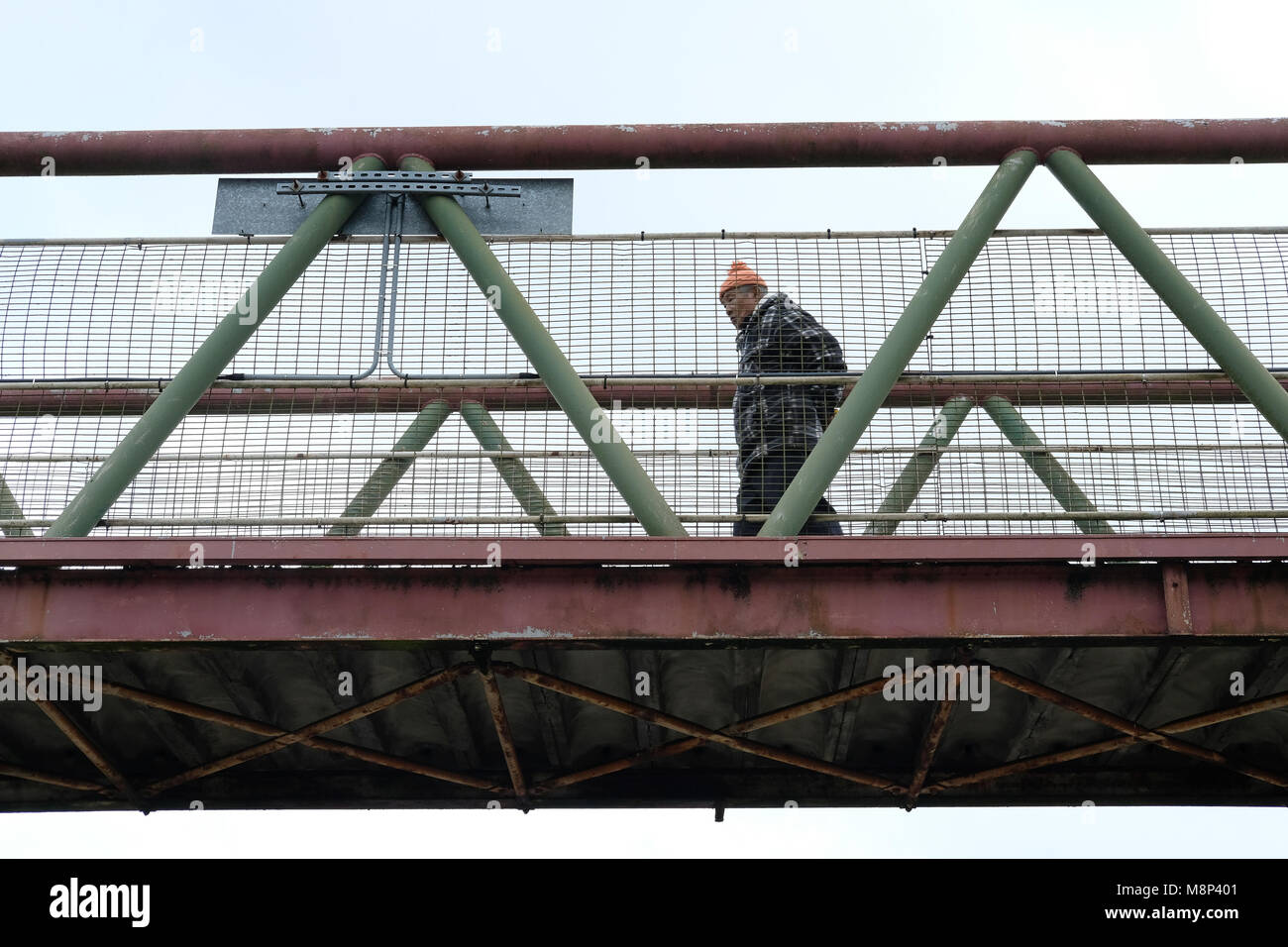 Un homme traverse le pont ferroviaire à Aldershot. Banque D'Images