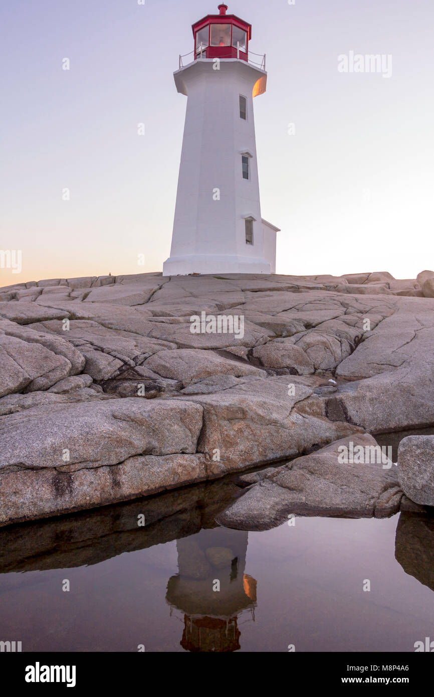 L'un des phares les plus photographiés du monde - Peggy's Cove, Nouvelle-Écosse reflètent dans une piscine dans les rochers à l'aube avec pas de touristes dans la région de View Banque D'Images