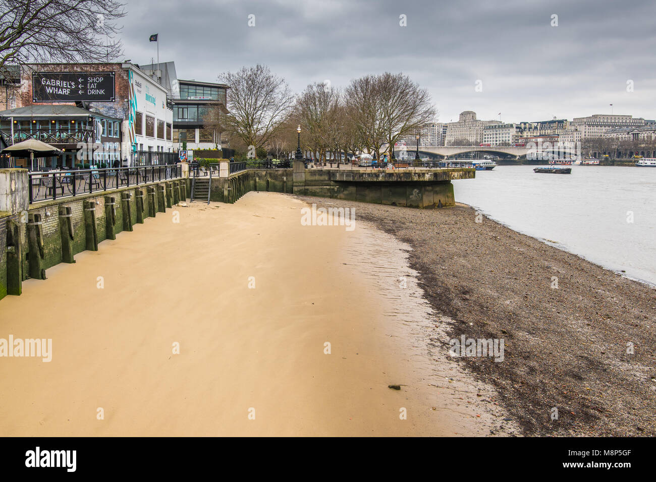 La plage de sable et de galets, avec la Tamise tide, à Gabriel's wharf par une froide journée de printemps sur la rive sud à Londres, en Angleterre. Banque D'Images