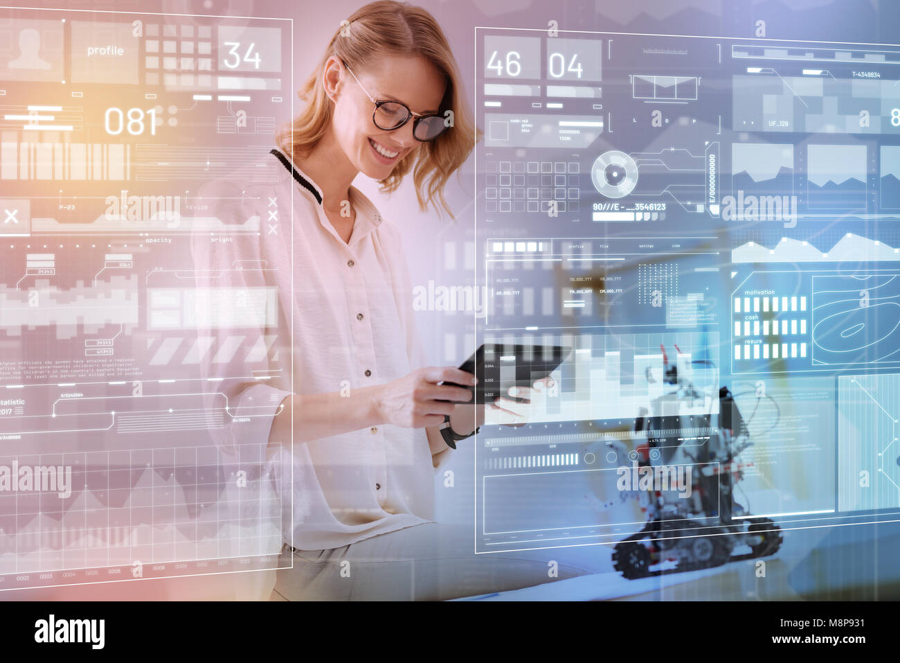 Ingénieur positive tenant une tablette moderne tout en testant un nouveau robot Banque D'Images