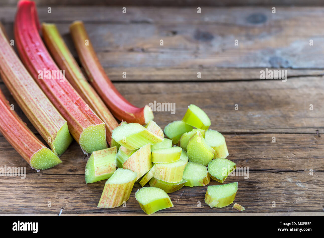Et des morceaux de rhubarbe fraîchement coupées sur fond rustique foncé Banque D'Images