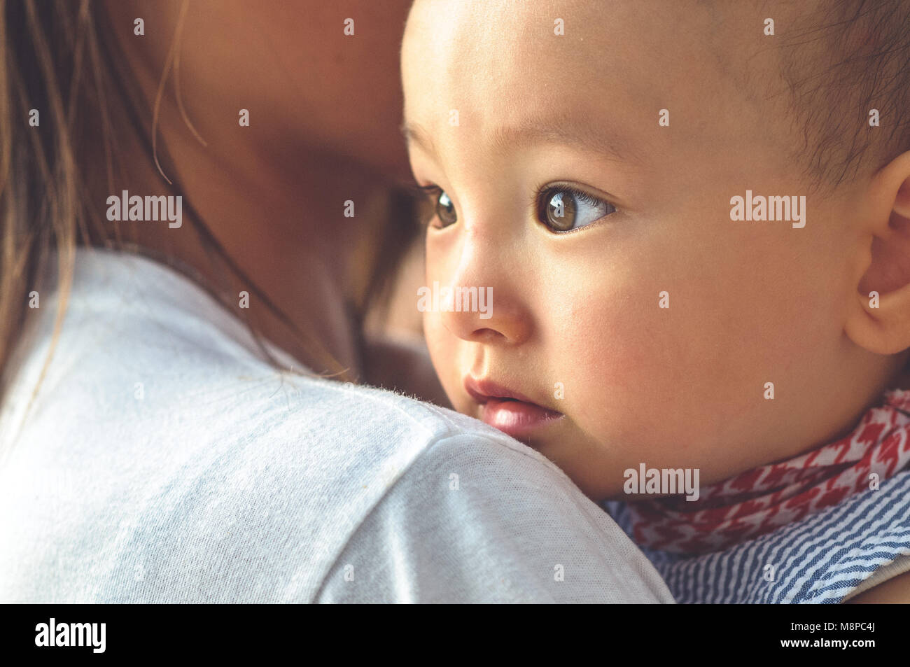Cute Asian baby face dans les bras de sa mère Banque D'Images