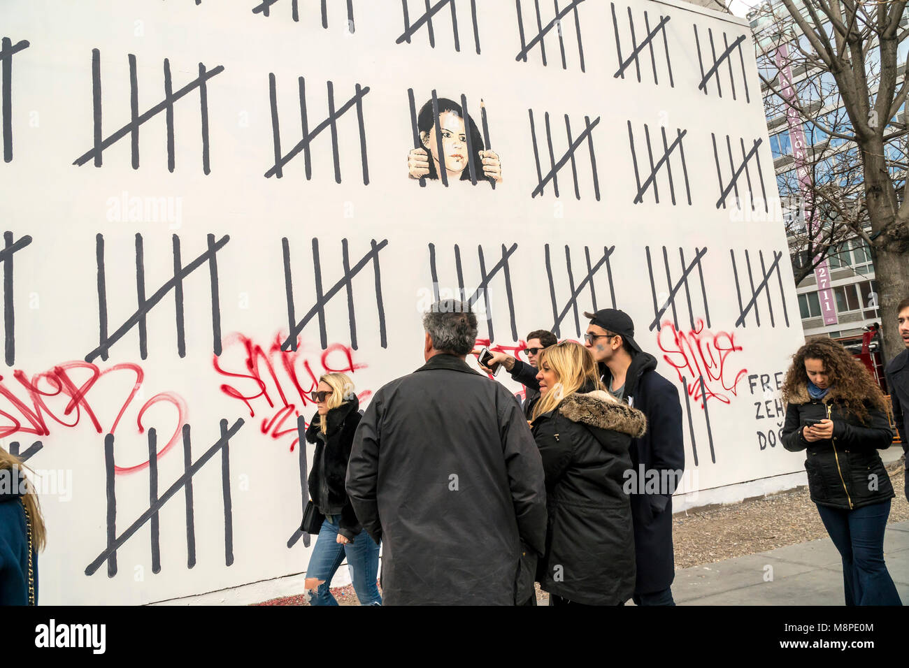 Les amateurs d'art de rue se rendent dans la 'Bowery Mur sur Houston Street, à New York, le Samedi, Mars 17, 2018 pour voir et photographier l'artiste Banksy's collaboration avec l'artiste de rue, Borf. Le travail est un hommage à l'artiste kurde turc emprisonné Zehra Dogan, qui a été arrêté pour la peinture un travail doté d''une ville kurde en ruines après un conflit entre l'armée et rebelles kurdes. Le travail de Banksy, précédemment paru à New York en octobre 2013 lorsqu'il a créé une œuvre par jour pendant un mois son 'residency'. (Â© Richard B. Levine) Banque D'Images