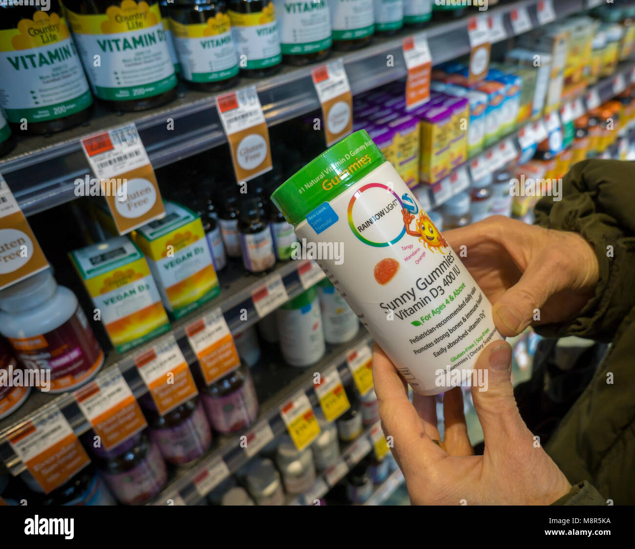 Un consommateur choisit un pot de lumière Arc-en-ciel supplément vitaminique dans un magasin à New York Lundi, 12 mars, 2018. Le Nutranext Clorox Co. est l'achat, le fabricant des suppléments, pour $700 millions de l'expansion de ses compléments alimentaires entreprise.(Â© Richard B. Levine) Banque D'Images