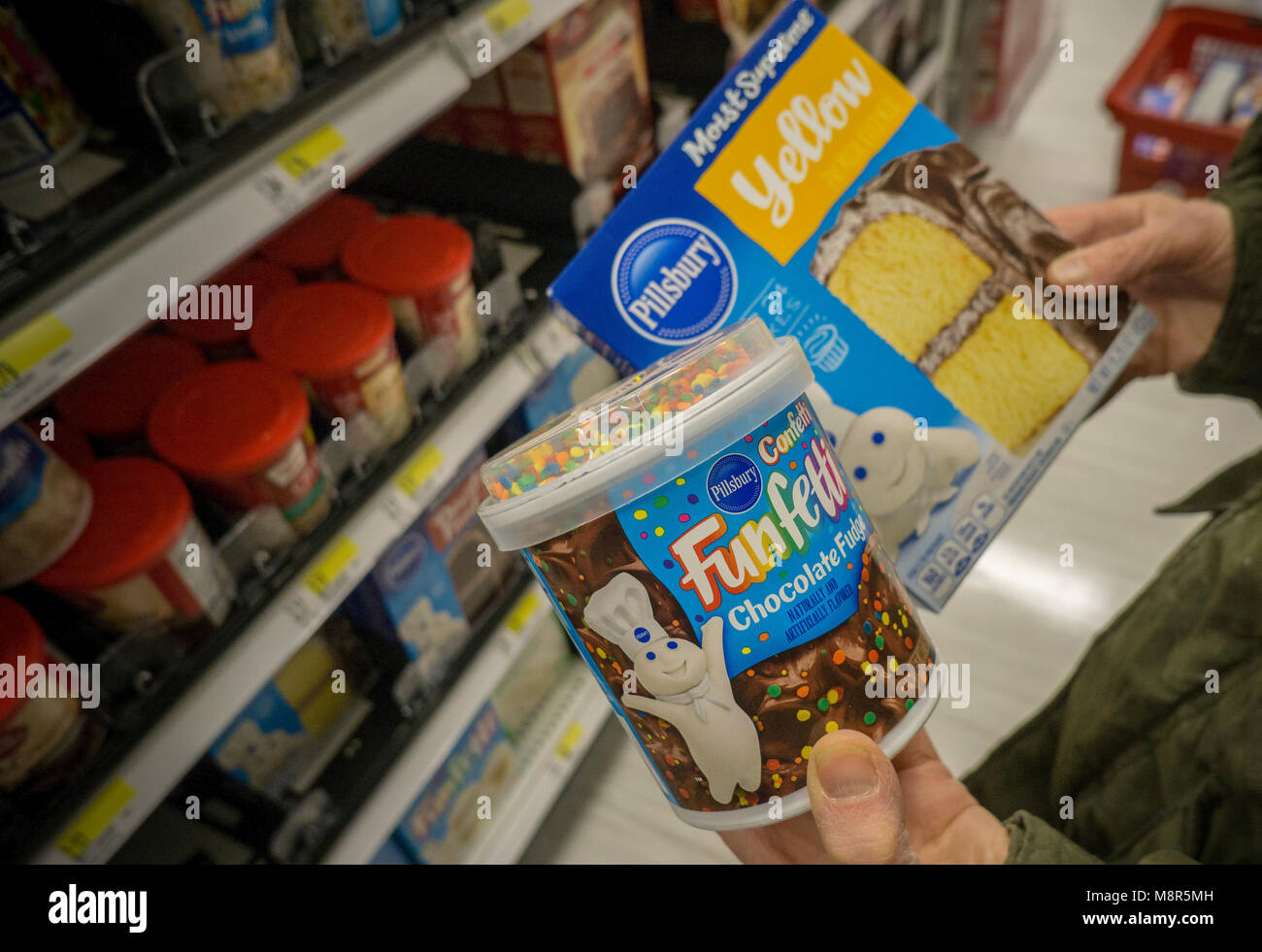 Un nouveau client compare les emballages de marque Pillsbury baking supplies dans un supermarché de New York le vendredi 9 mars 2018. J.M. Smucker, le propriétaire de la marque Pillsbury, serait d'envisager une vente de ses marques de cuisson qui est estimé à vendre pour 700 millions de dollars. (Â© Richard B. Levine) Banque D'Images