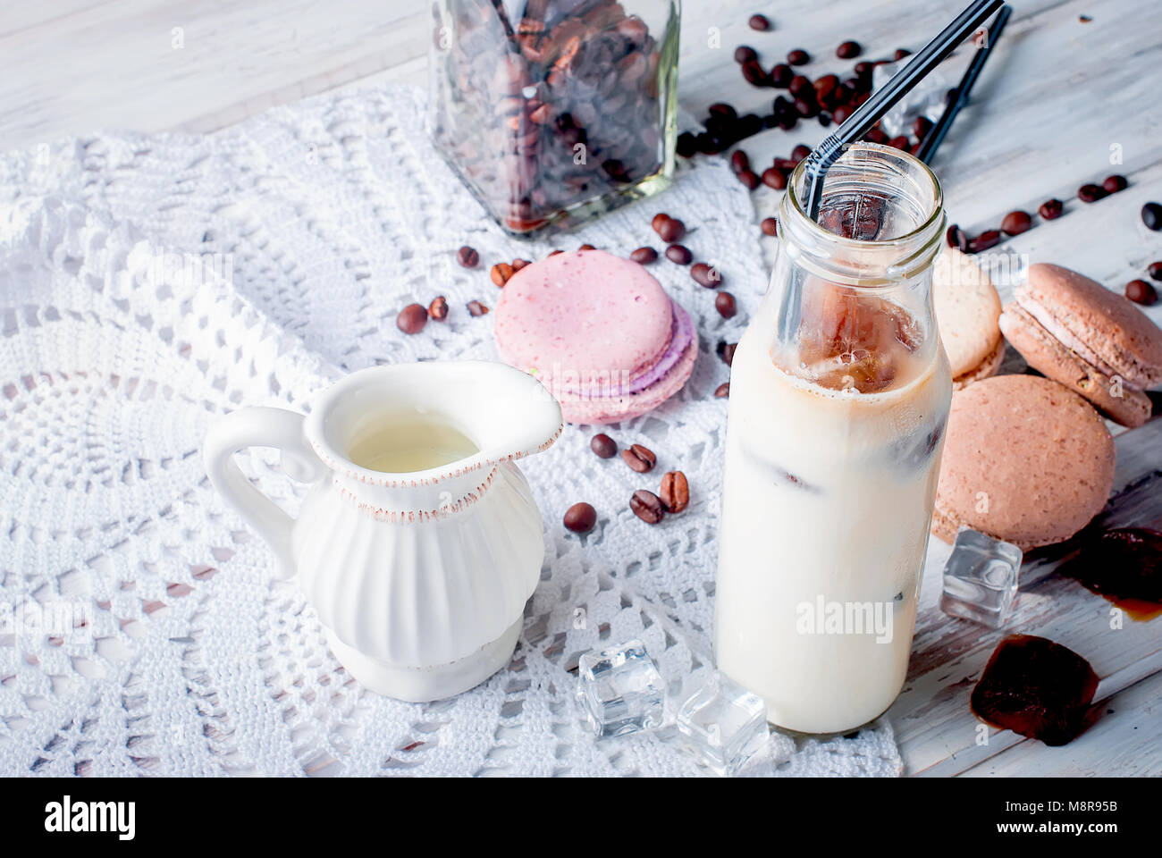 Glace café en verre, macarons,, morceaux de chocolat et les grains de café sur une table gris , vue d'en haut, copy space Banque D'Images