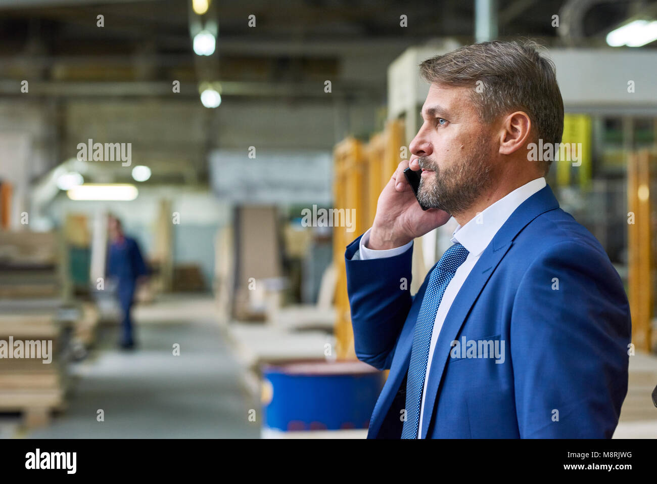 Manager parlant par téléphone en usine Banque D'Images