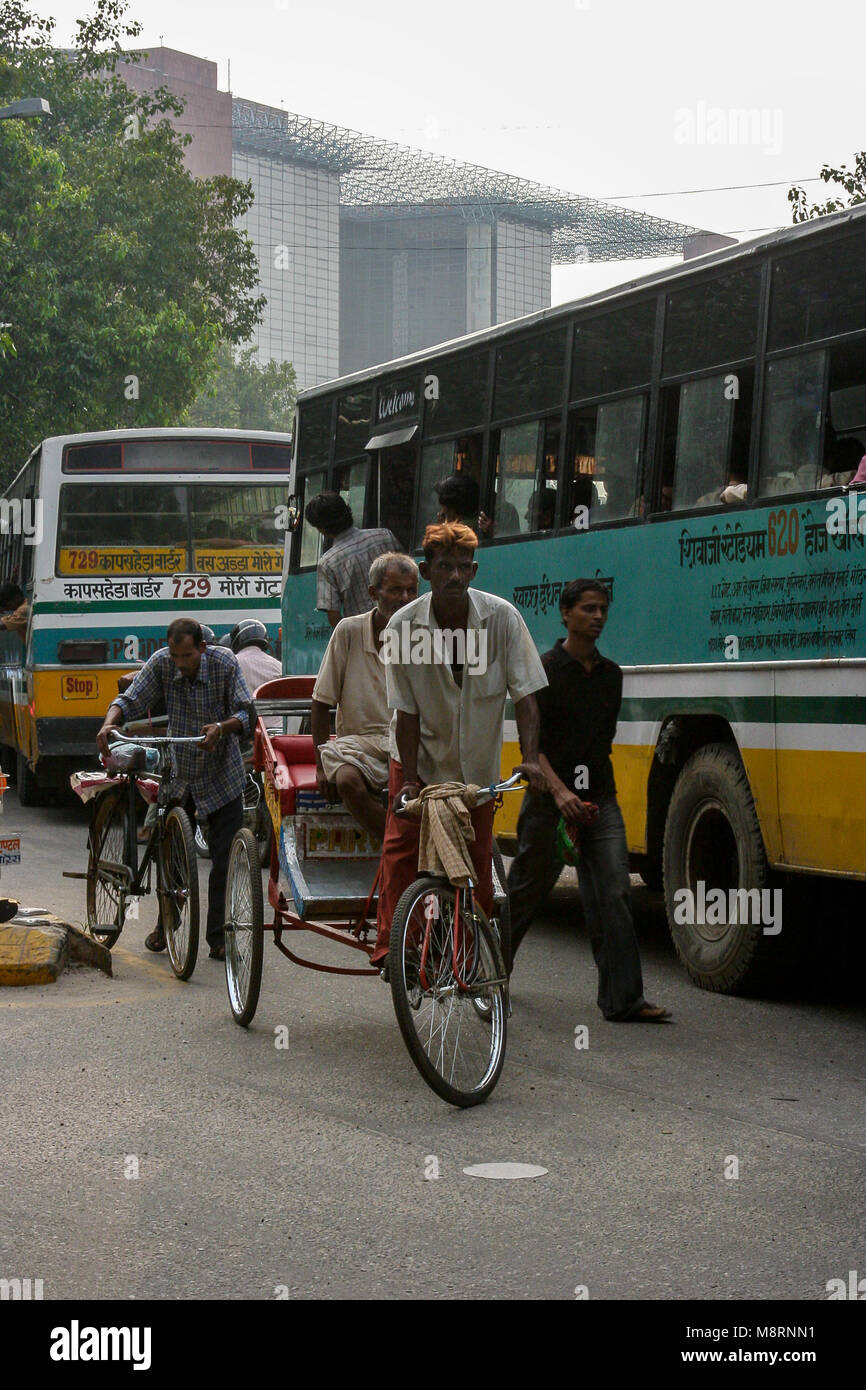 New Delhi, Inde : un rickshaw indien jongle dans un embouteillage d'autobus à New Delhi. Banque D'Images