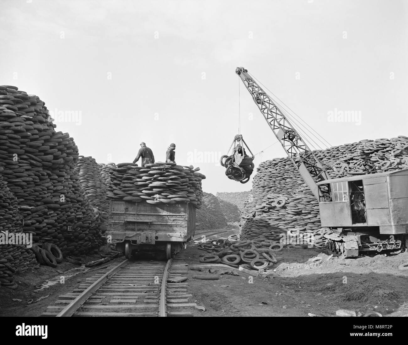 Empilage de travailleurs jetés à l'enveloppe avec l'usine de récupération de matières de récupération pour être transformés en des milliers de produits en caoutchouc mécaniques essentielles, Firestone Tire and Rubber Company, Akron, Ohio, USA, Alfred T. Palmer pour l'Office of War Information, décembre 1942 Banque D'Images