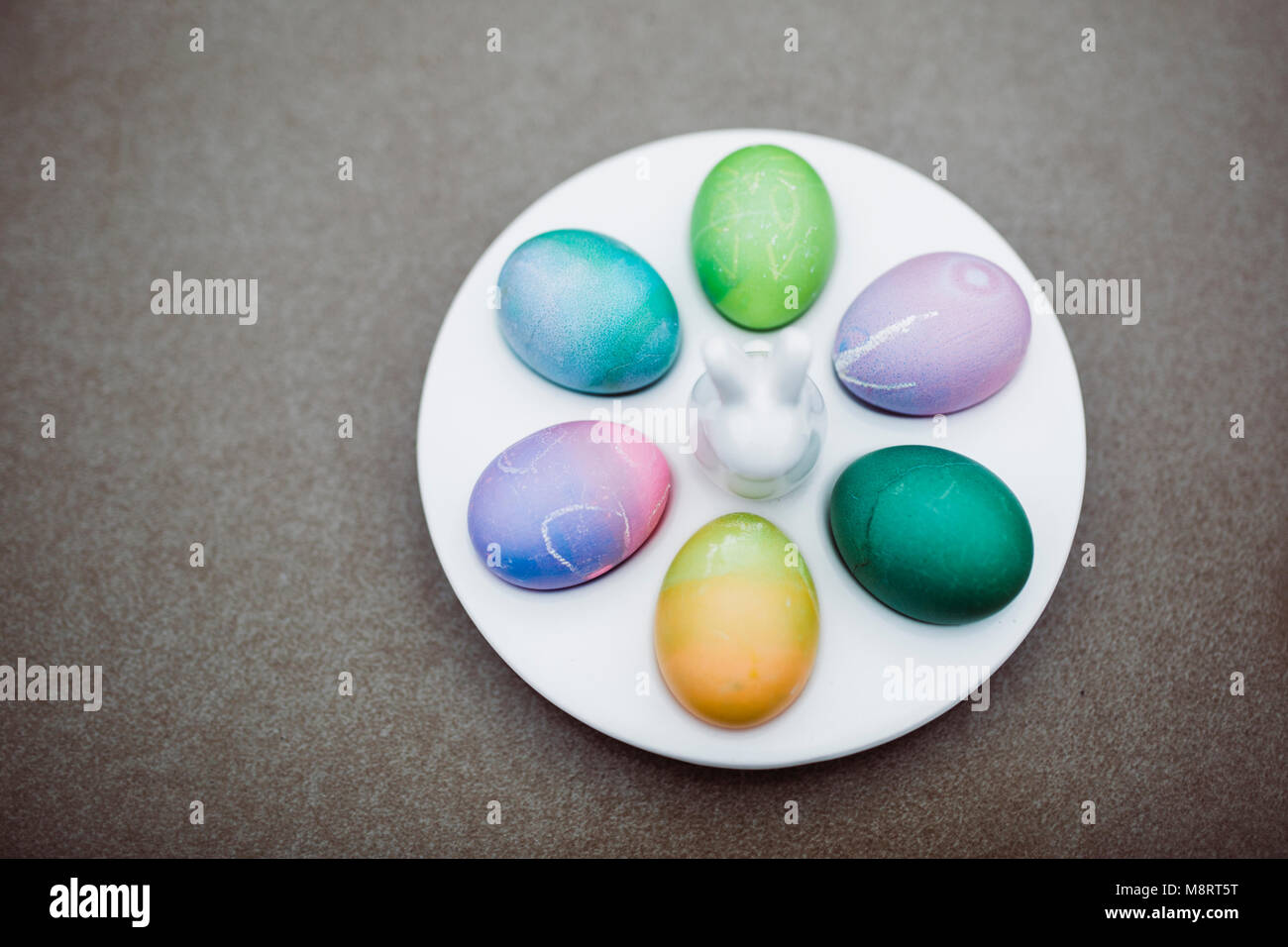 Vue en angle élevé des oeufs de pâques colorés dans l'assiette sur la table Banque D'Images