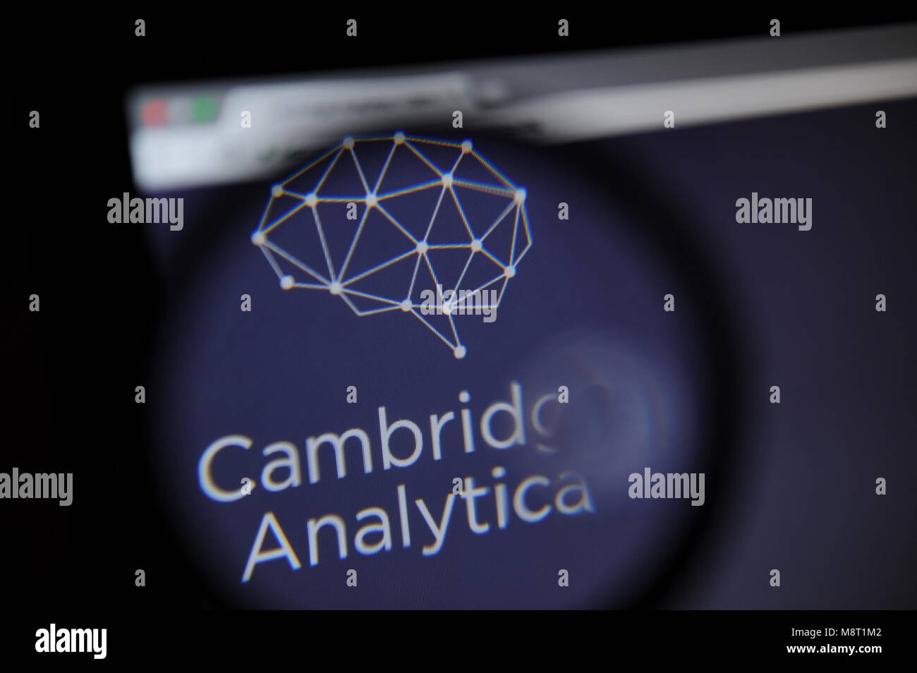 Le site web de l'Analytica Cambridge est vu à travers un verre magnifiying Banque D'Images