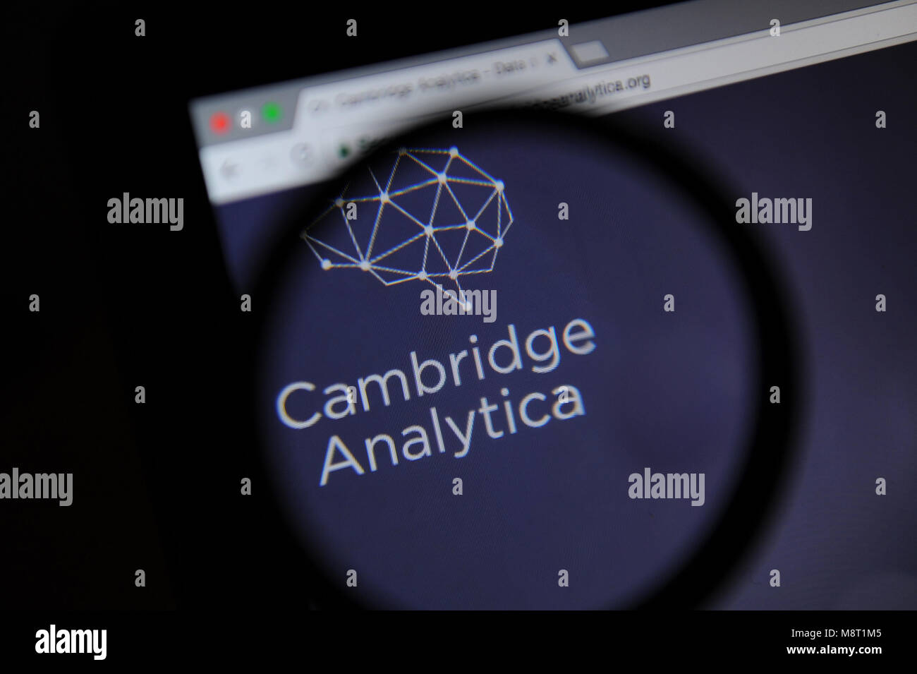 Le site web de l'Analytica Cambridge est vu à travers un verre magnifiying Banque D'Images